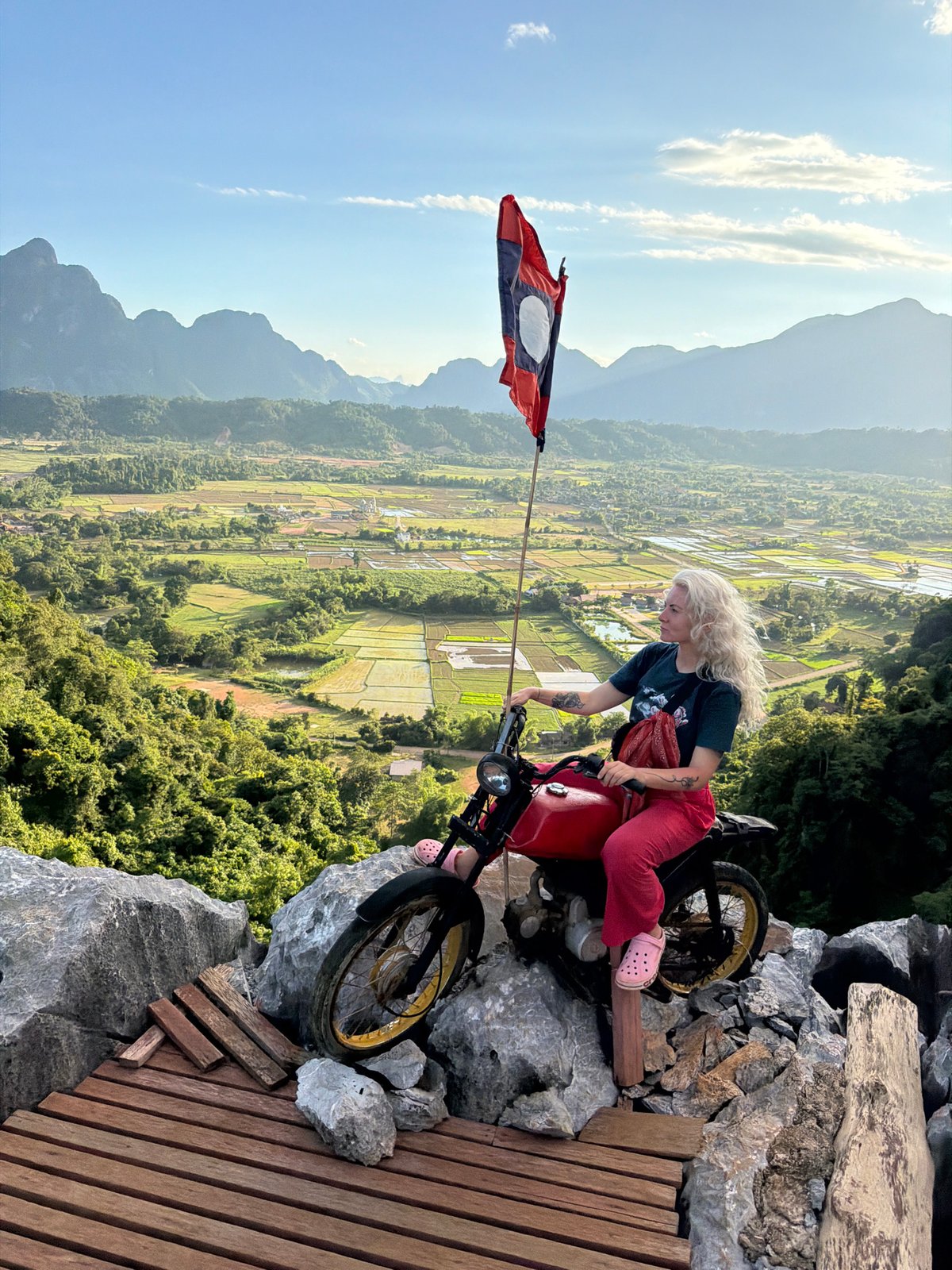 Parked on a red motorcycle in rural Laos