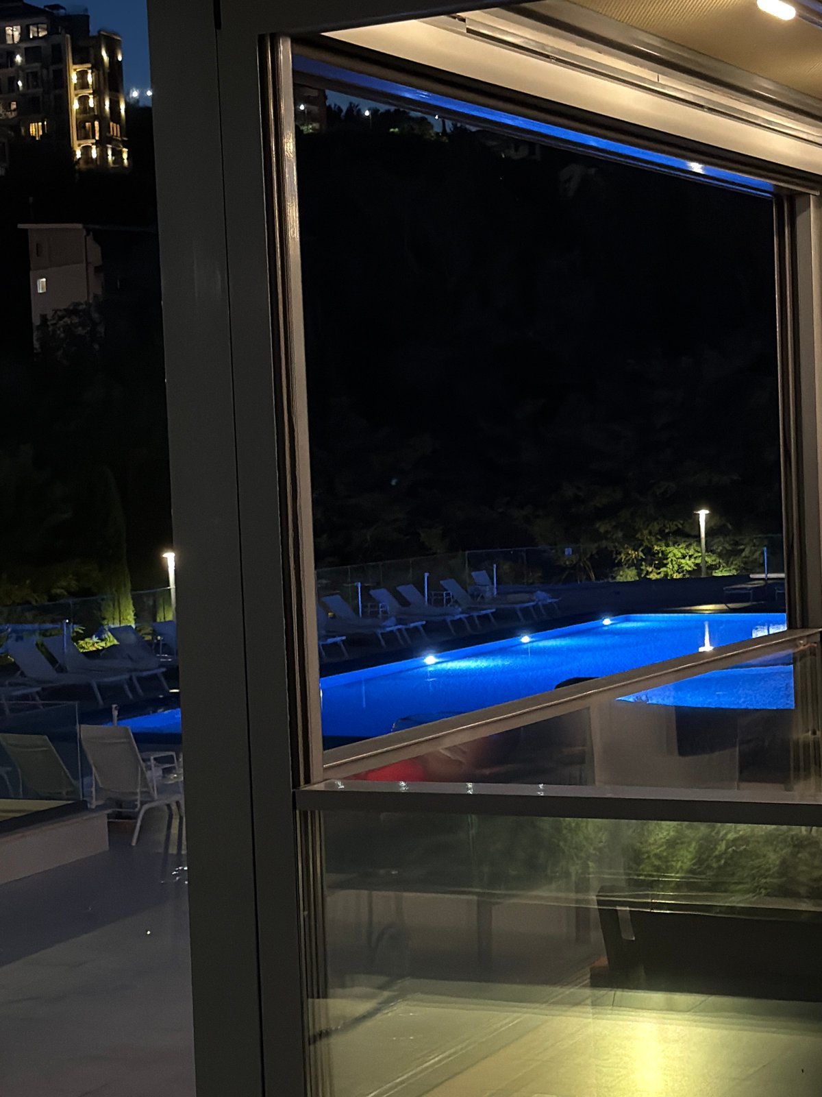 Lit pools and crescent moon on the Montenegro coast at night