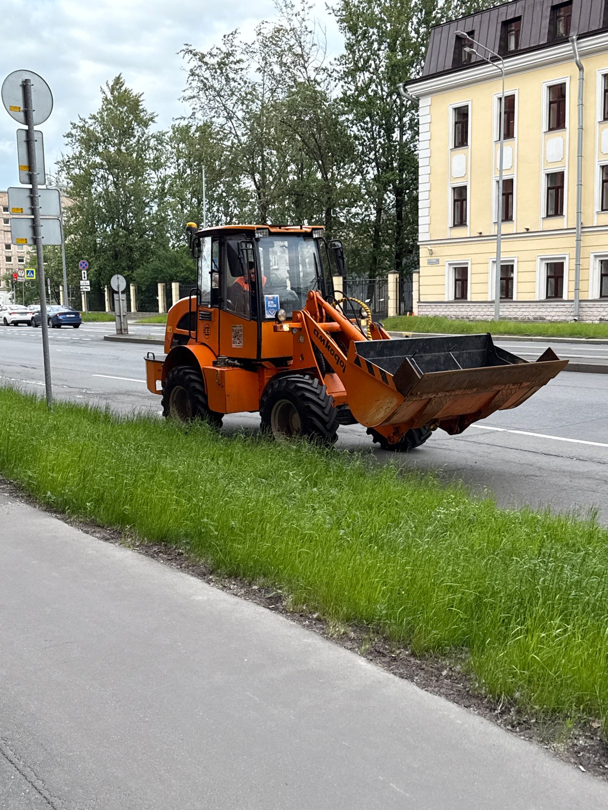 Orange loader parked and moving on a Saint Petersburg street