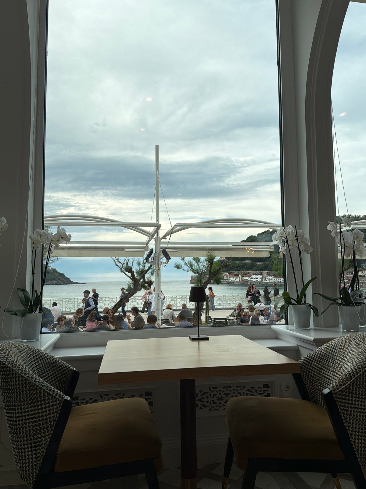 Elderly couple dines overlooking La Concha beach, San Sebastián