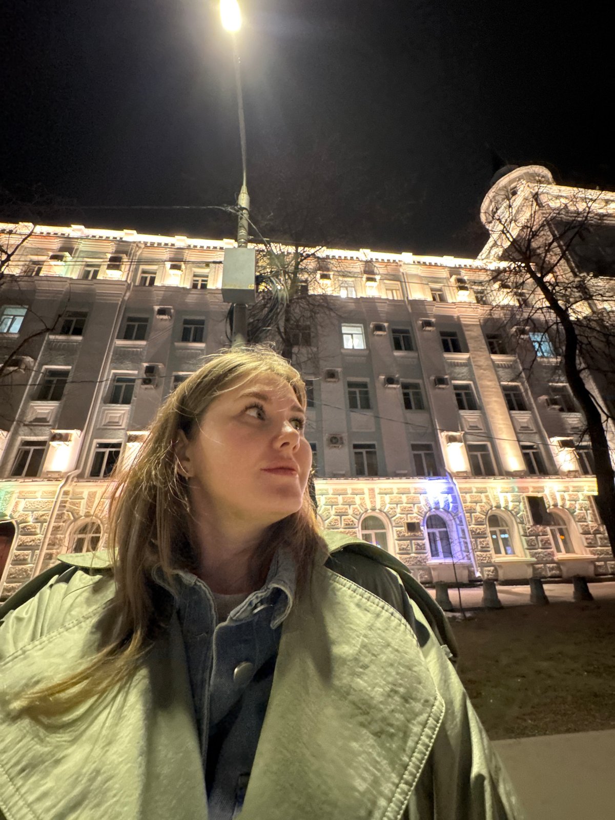 Evening gathering outside illuminated building in Perm, Russia