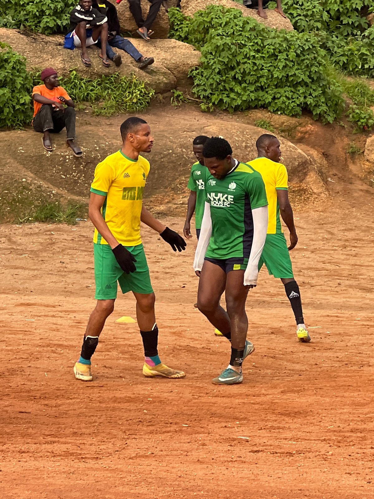 Informal soccer match on a rocky dirt pitch in Jos, Nigeria