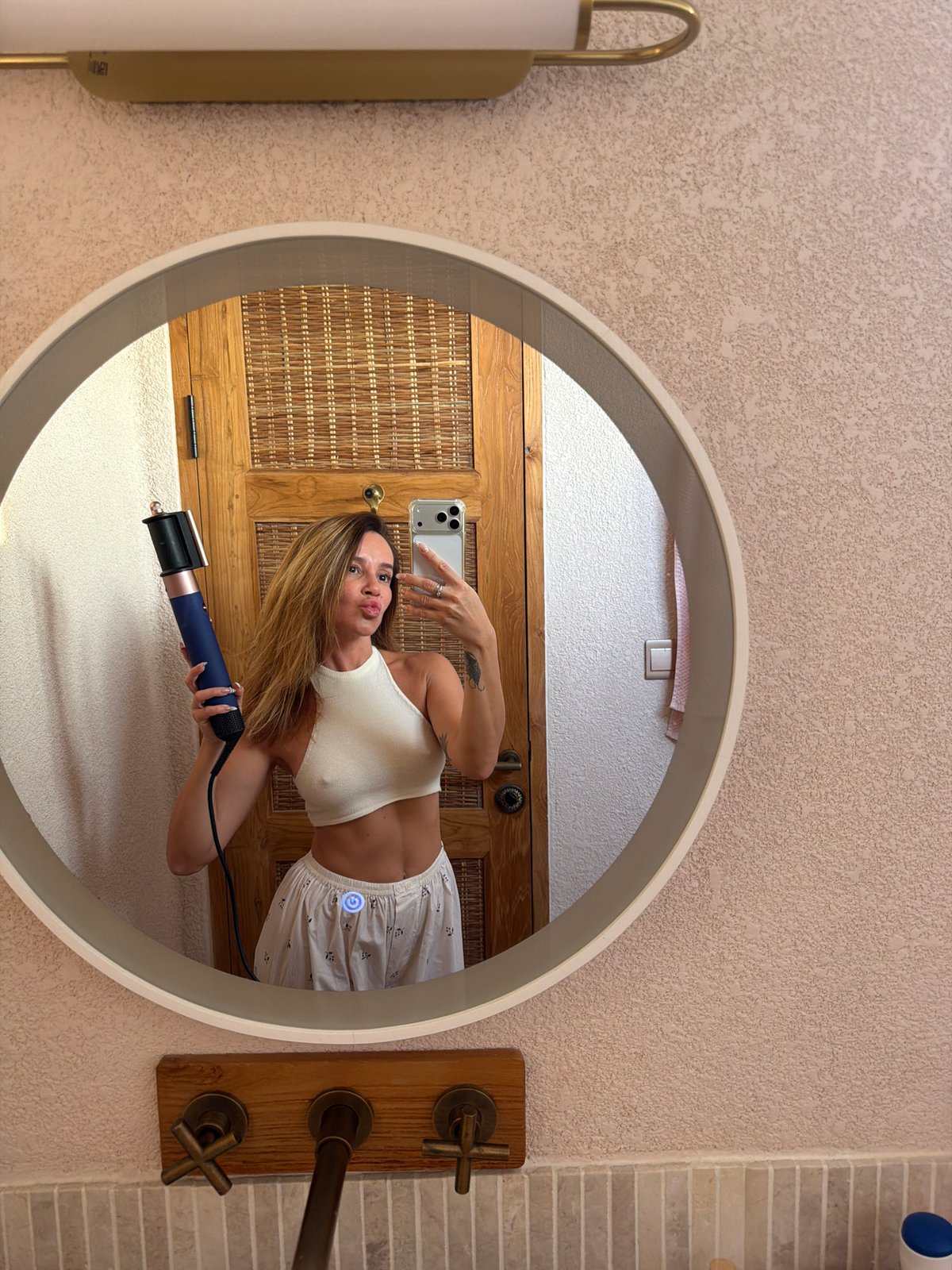 Woman takes bathroom selfie amid skincare products in Mengwi