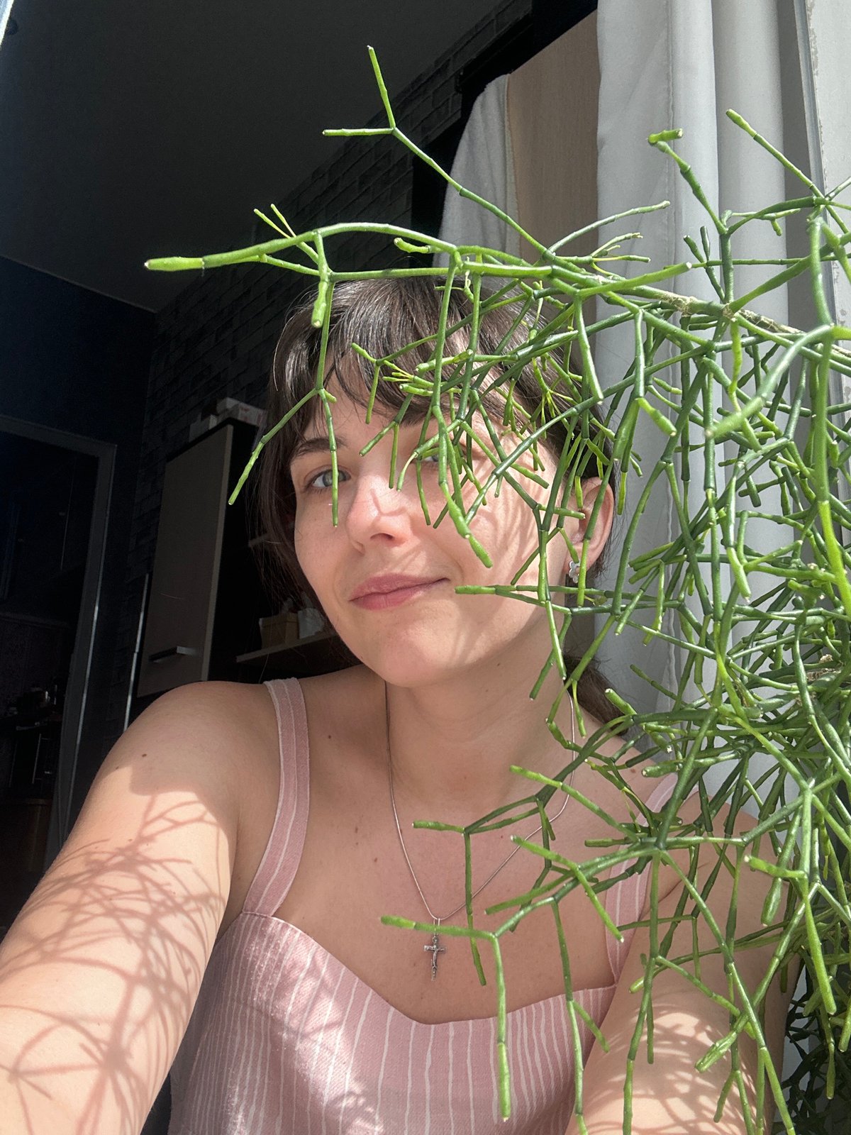 Woman poses with plant in Saint Petersburg apartment