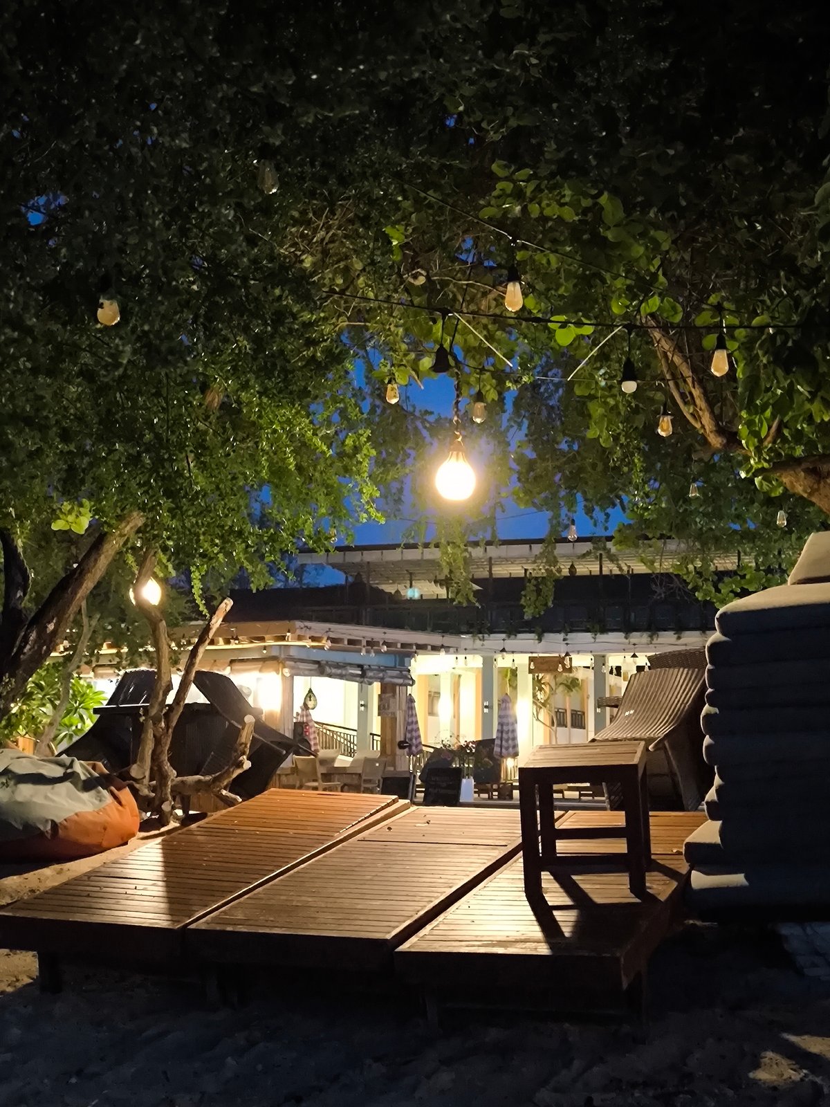 Evening beach dining area with string lights observed in Indonesia