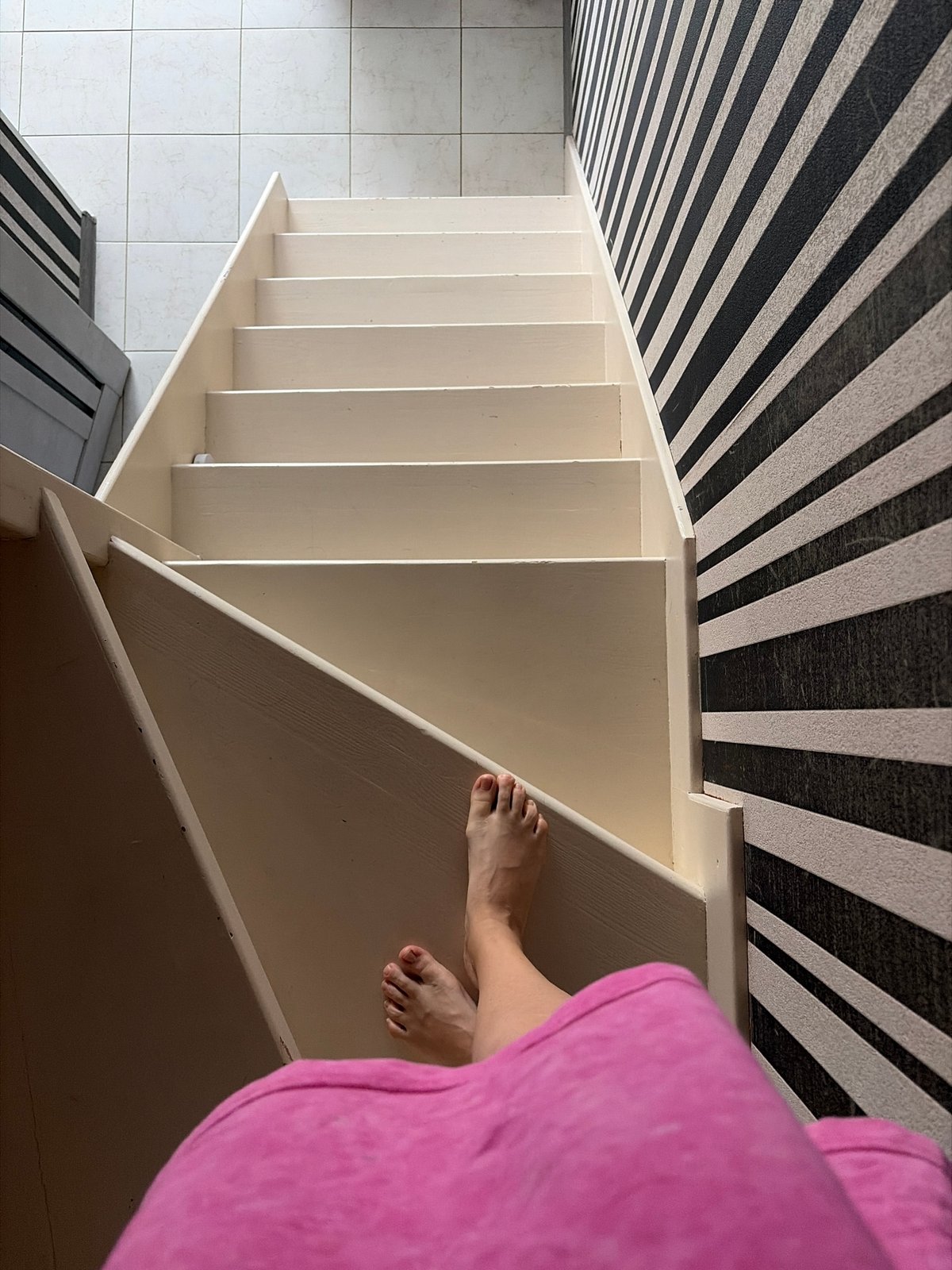 Wooden staircase with striped wallpaper in Sochi home