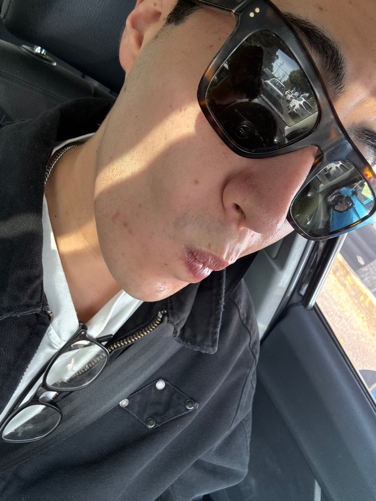 Person in tortoiseshell sunglasses photographed inside vehicle in Puebla