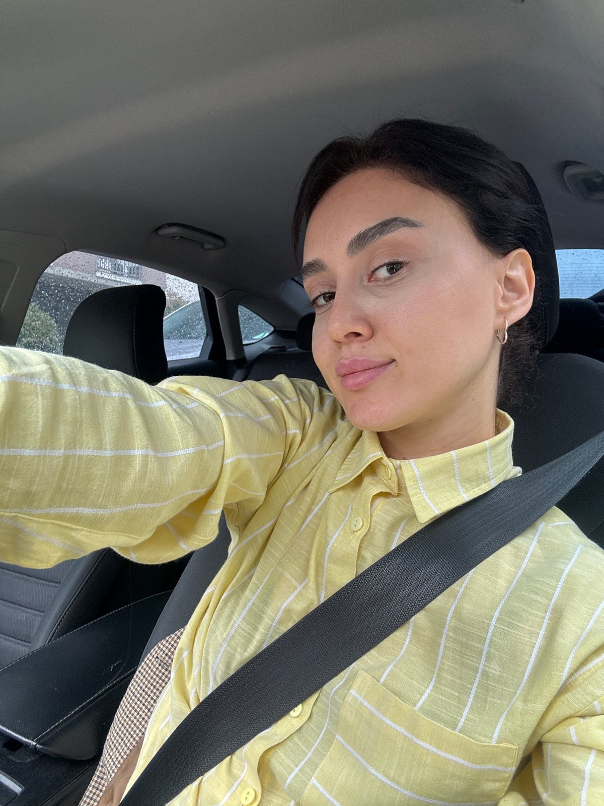 Woman in yellow striped shirt observed driving in Tbilisi