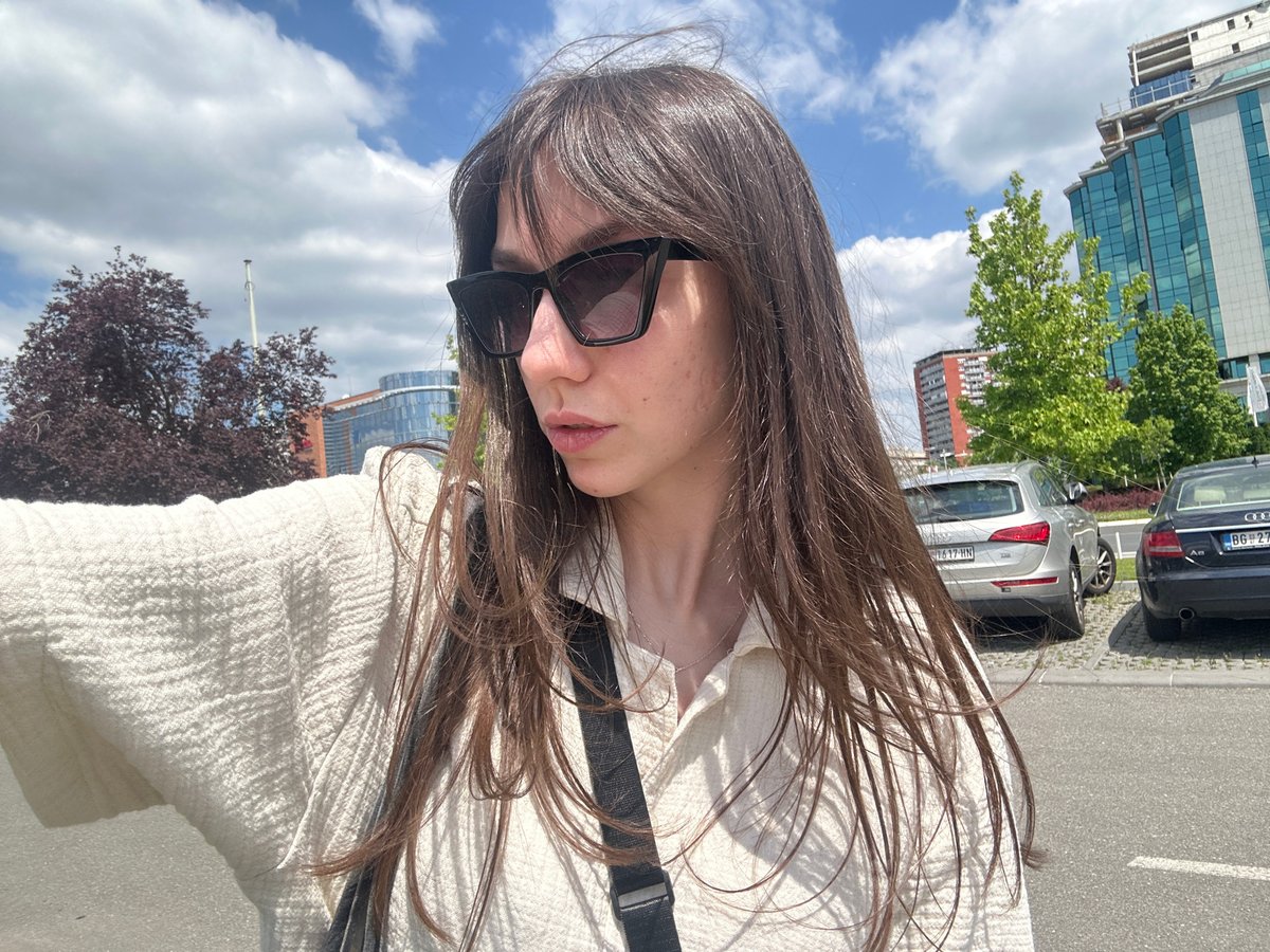 Woman photographed on Belgrade street amid parked cars