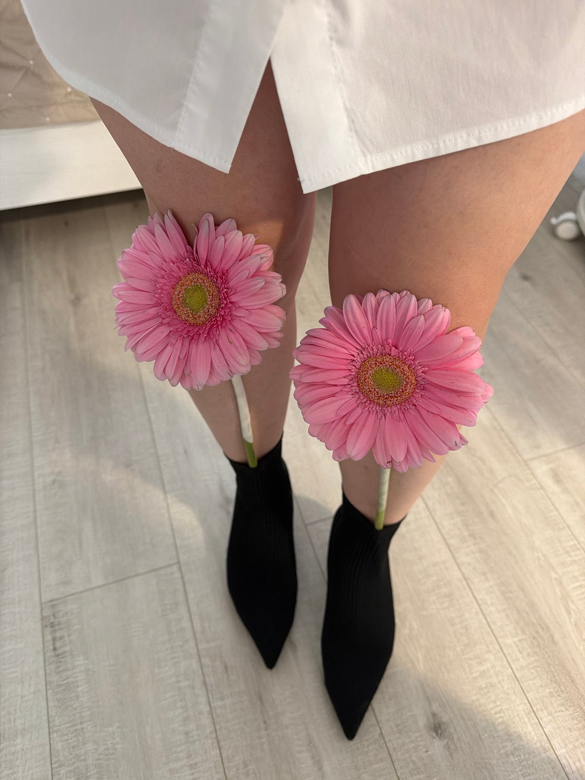 Person poses with pink flowers, takes selfie in Votkinsk