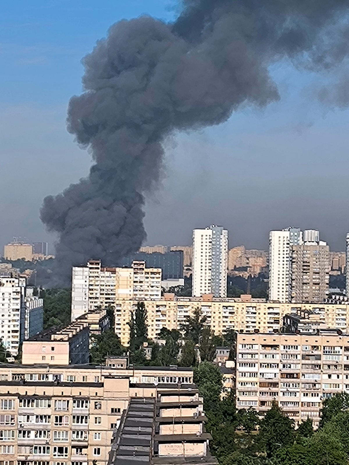 Black smoke over Kyiv with firefighting helicopter responding