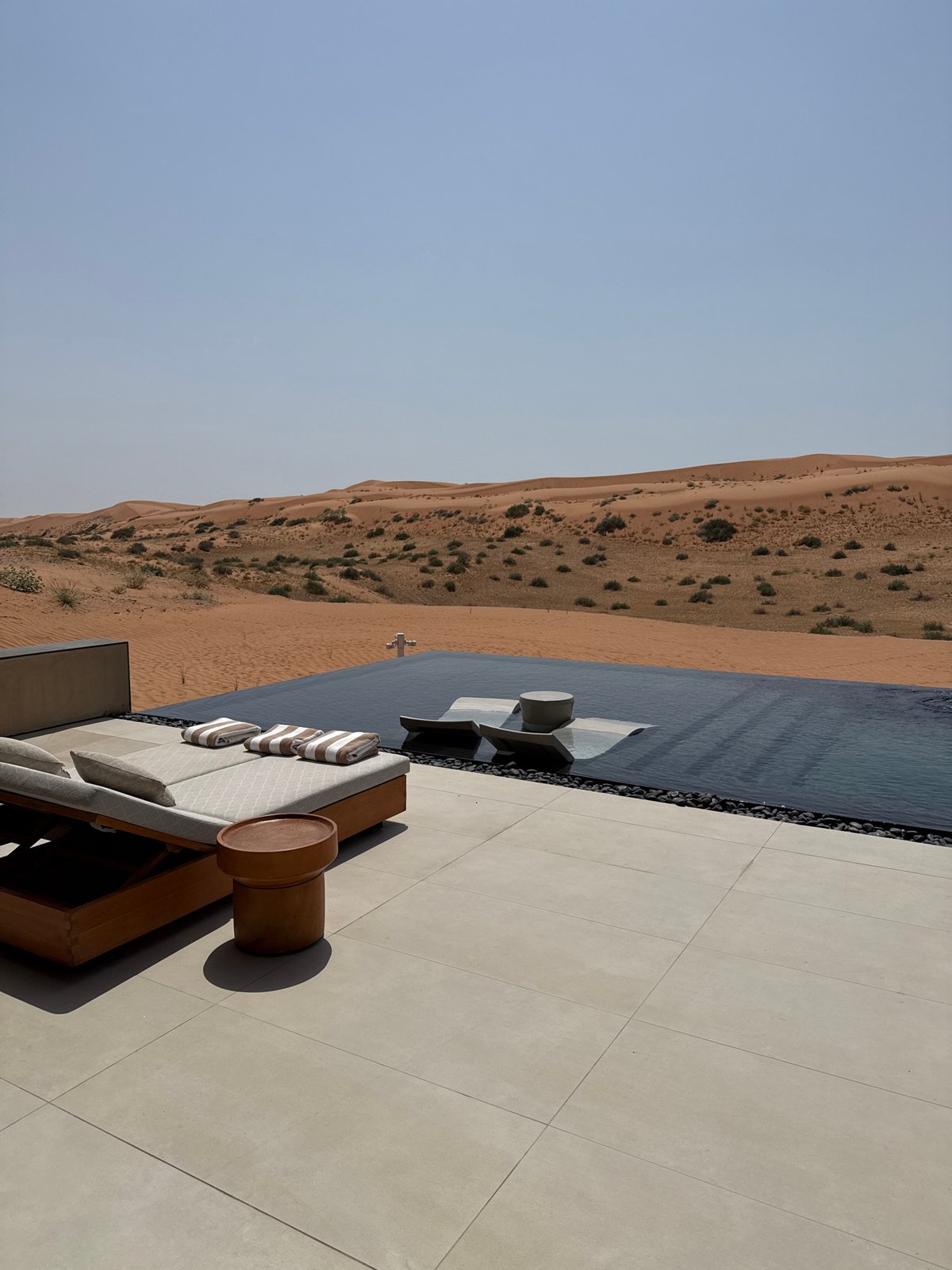 Luxury resort infinity pool and lounge overlooking RAK desert