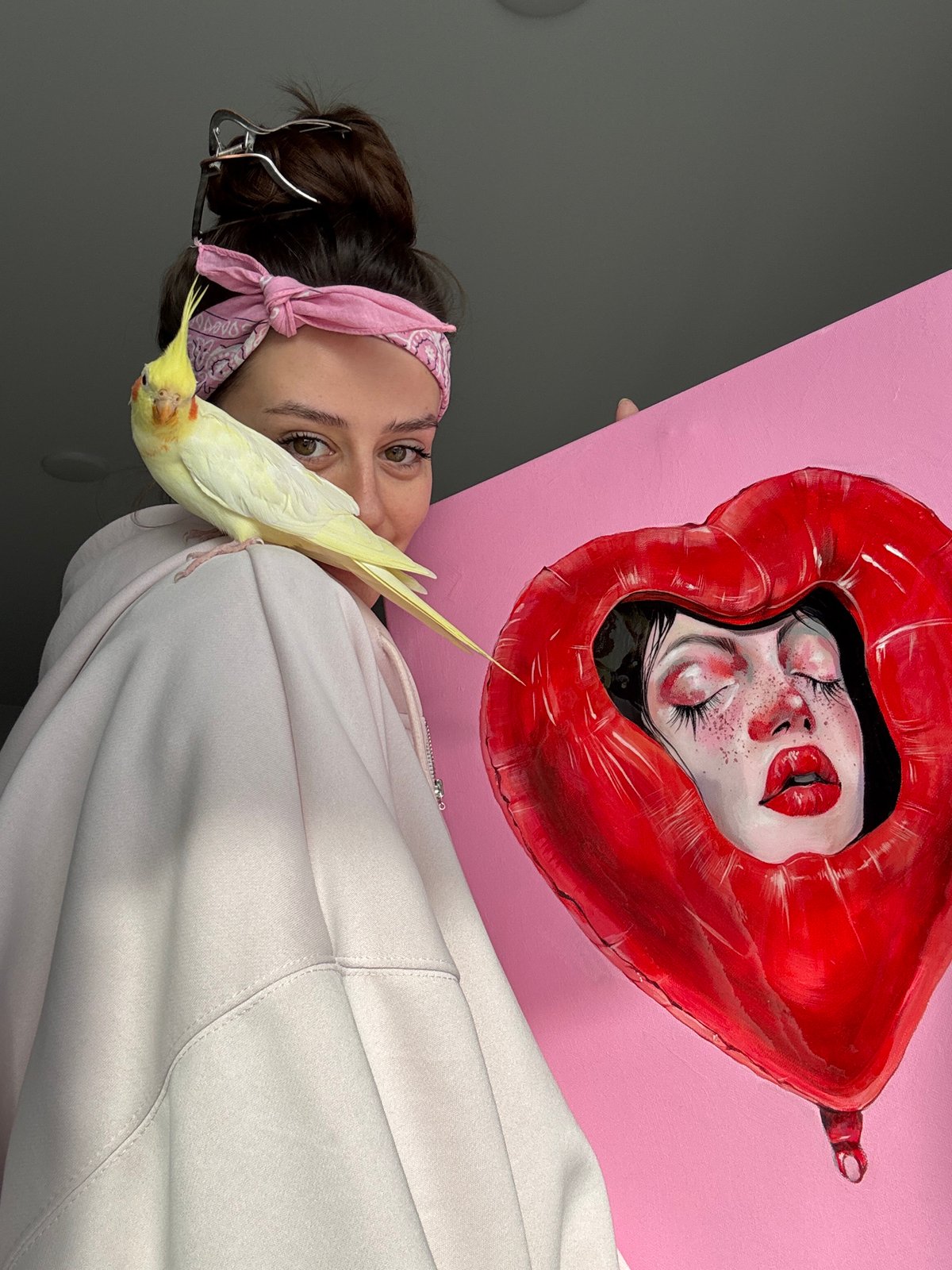 Artist documents creative work and pet cockatiel in Krasnoyarsk studio