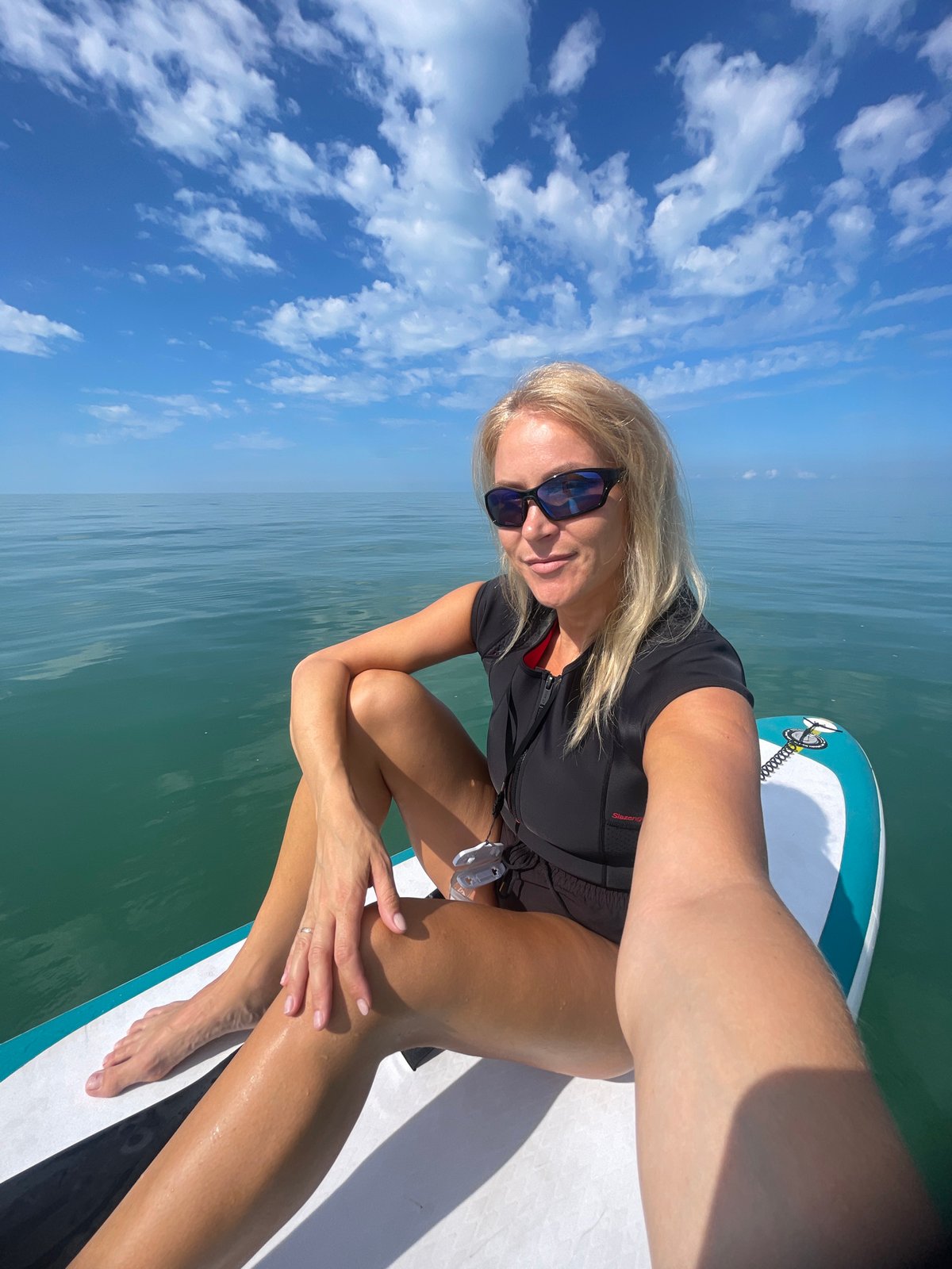 Woman paddleboards in calm waters near Khostinskiy, Russia