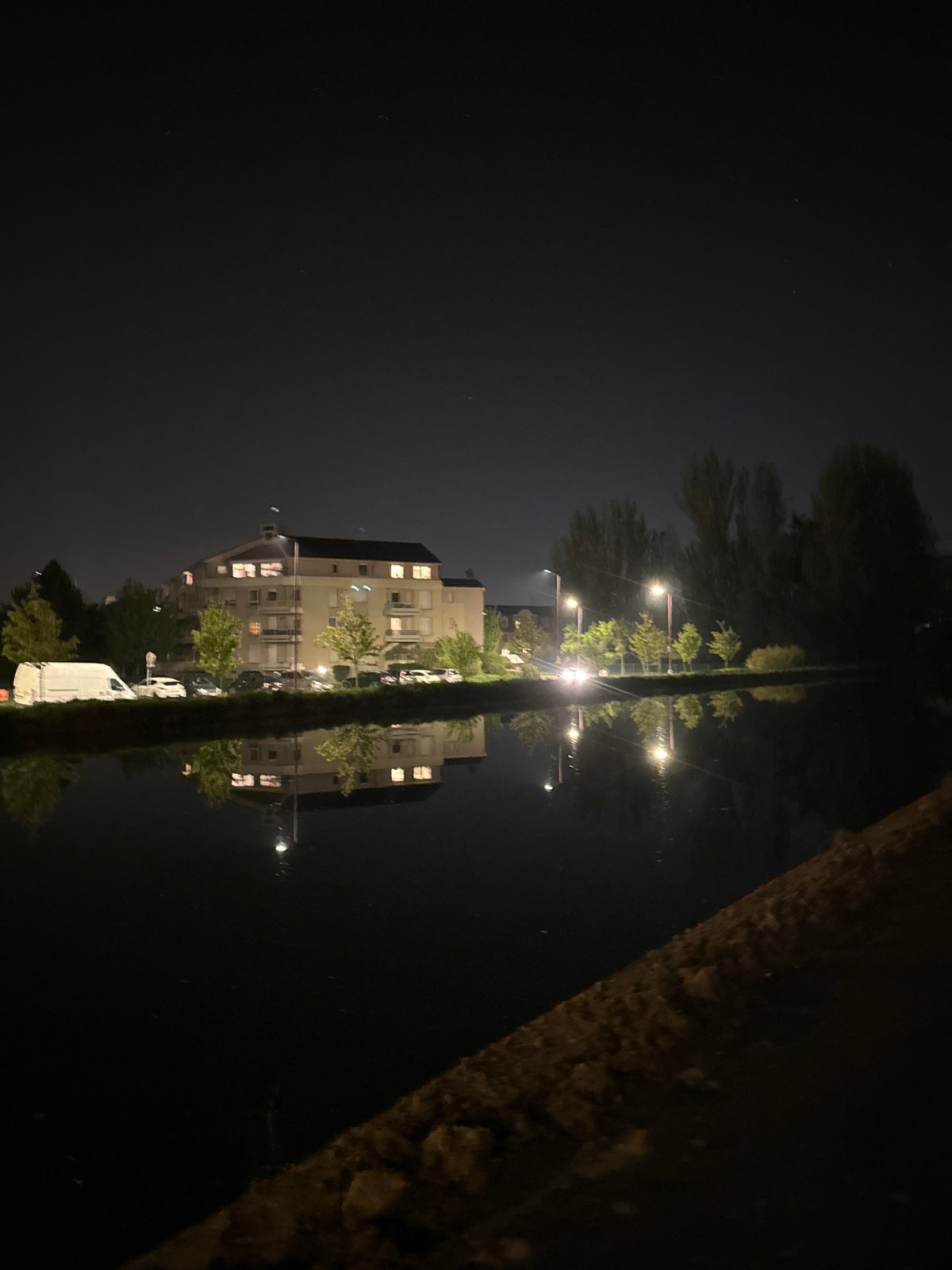 Illuminated building reflected in water at night in Bischheim