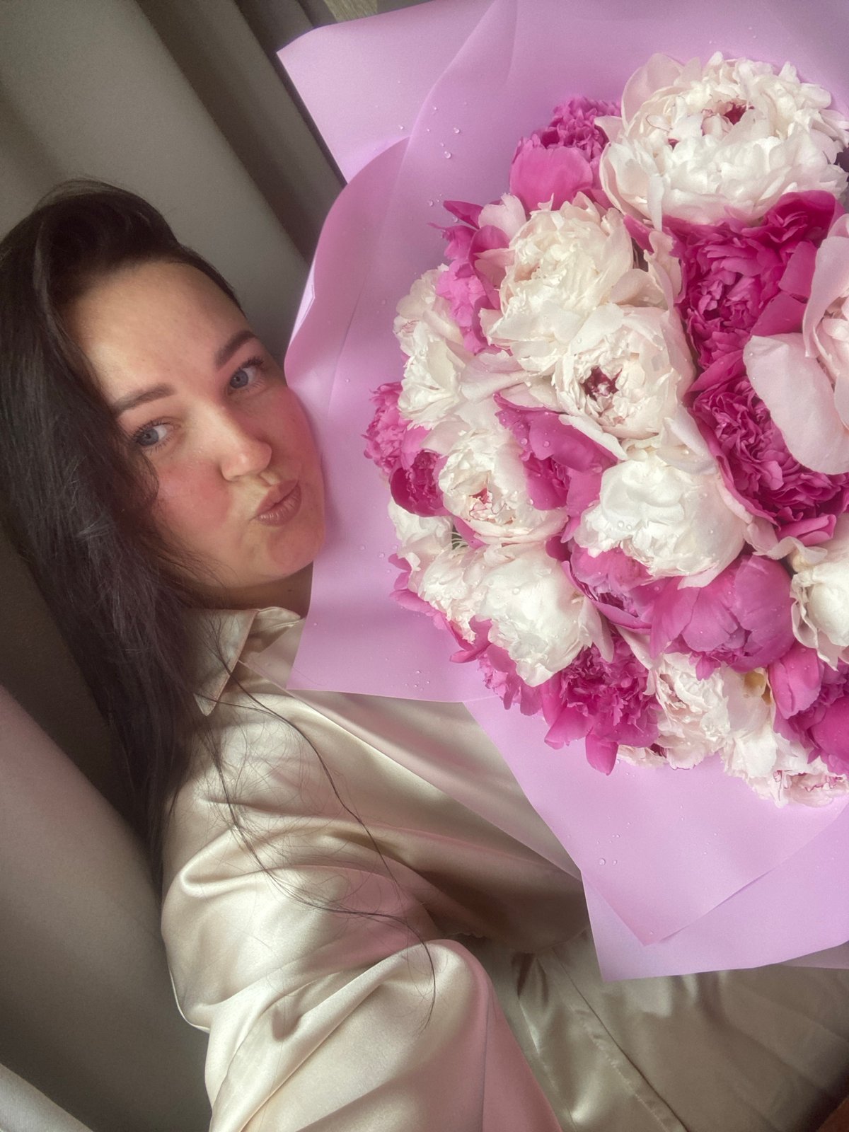 Woman poses with peony bouquet in Sochi bedroom