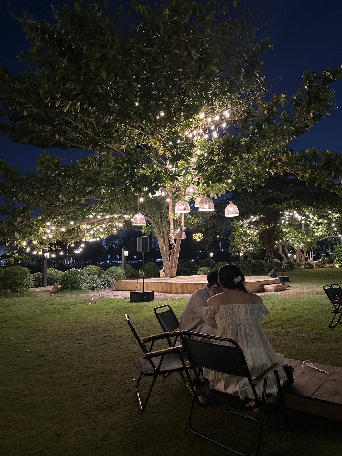 Woman dines at illuminated outdoor cafe in Ho Chi Minh City