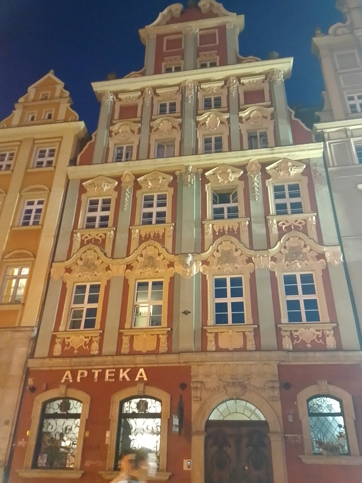 Evening stroll through illuminated Wrocław Market Square captures historic architecture