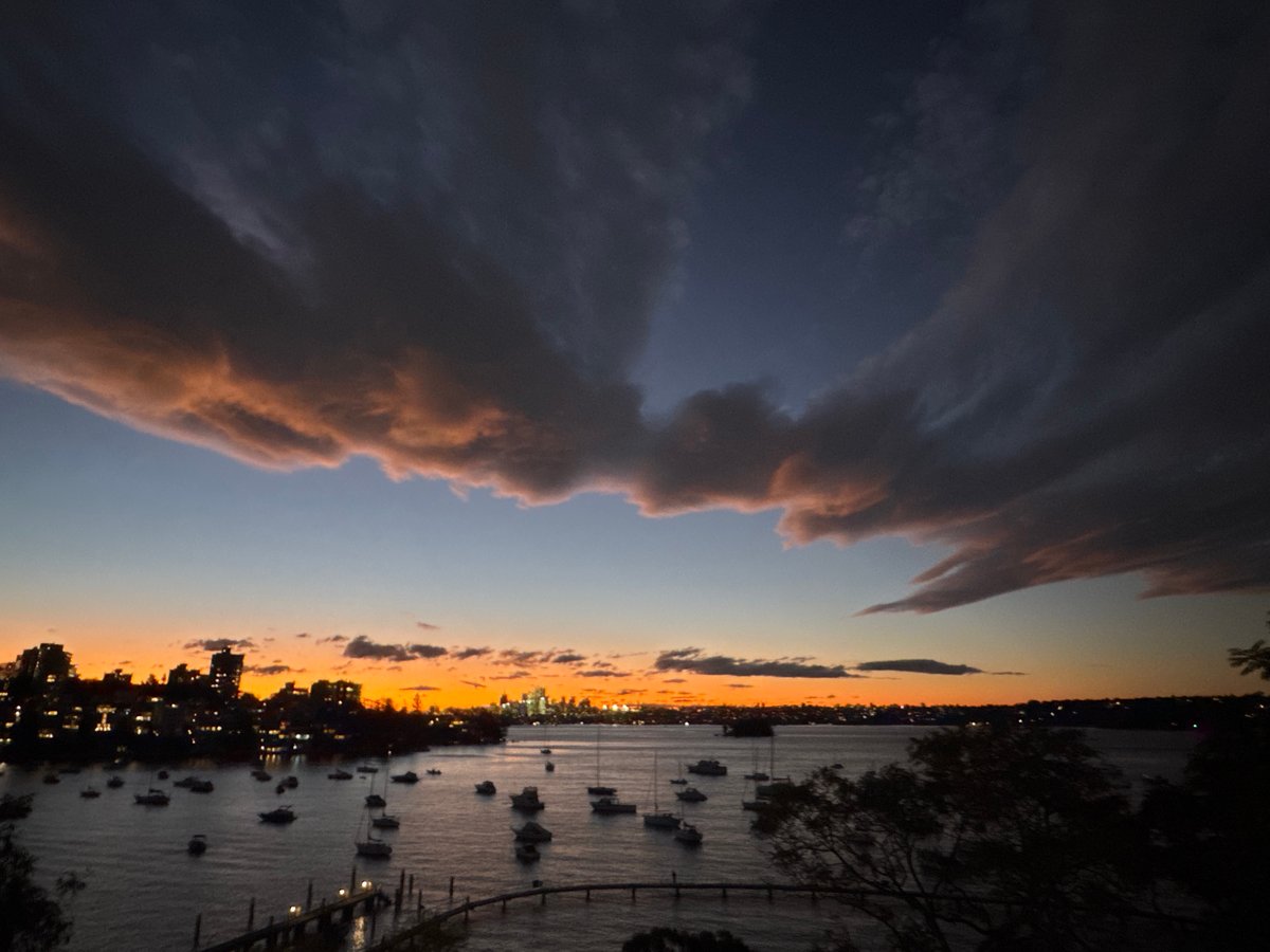 Sydney harbour glows under a dramatic dusk sky