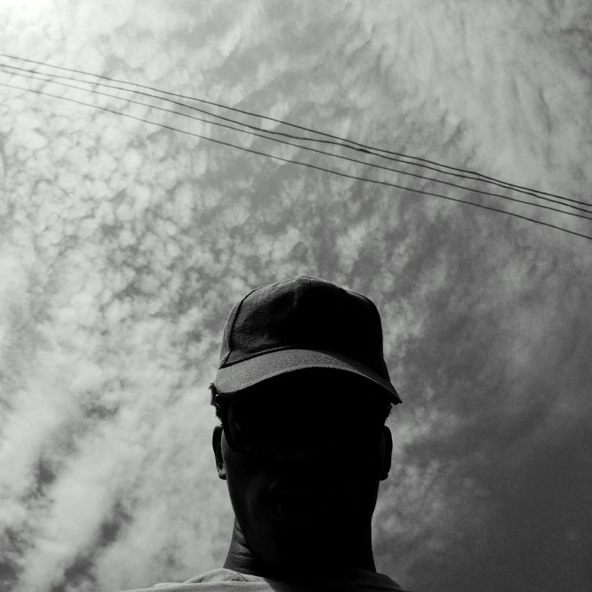 Person in baseball cap photographed under power lines
