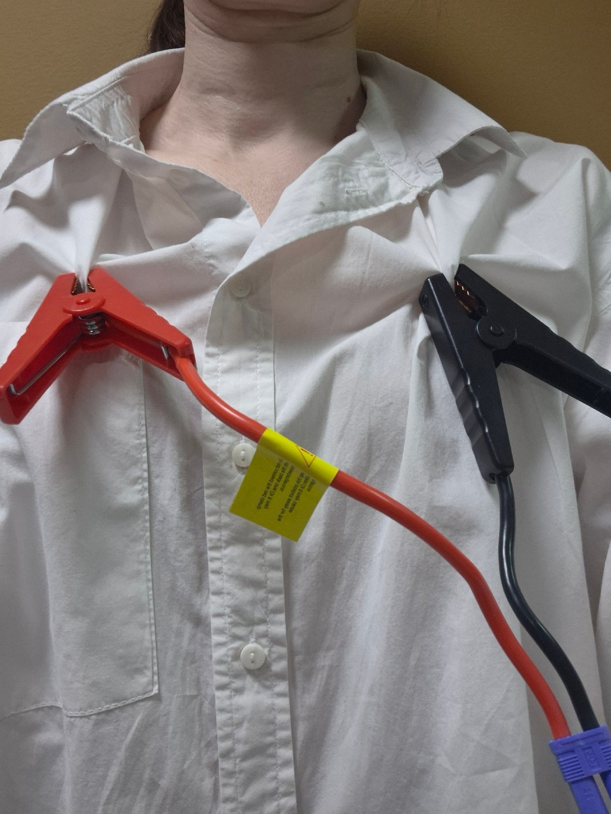 Person with jumper cables attached to shirt observed lying down