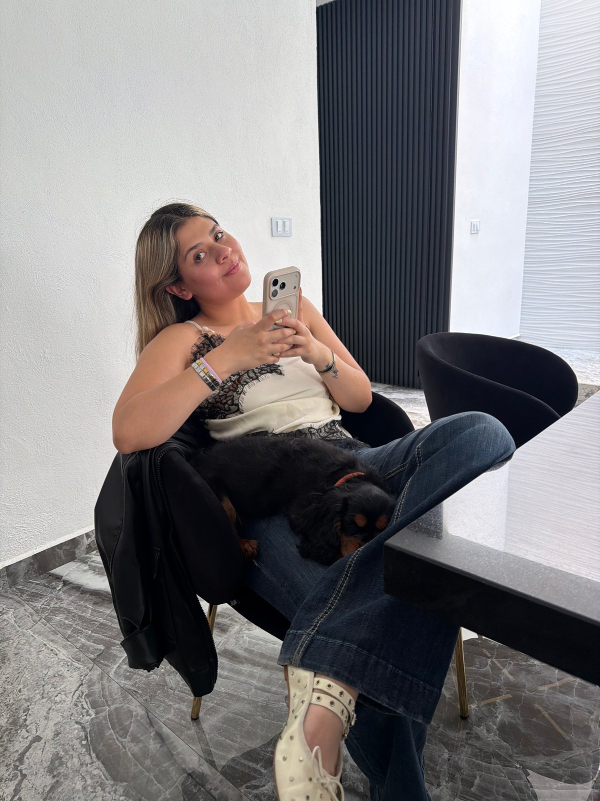 Woman relaxes with small dog indoors in Puebla