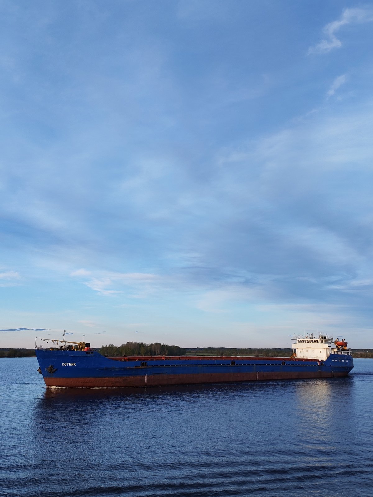 Cargo ships and tugboats transit Sheksna River in Russia