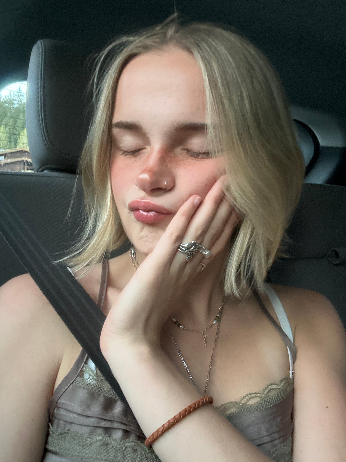 Woman photographed resting and taking selfies in car, Whistler
