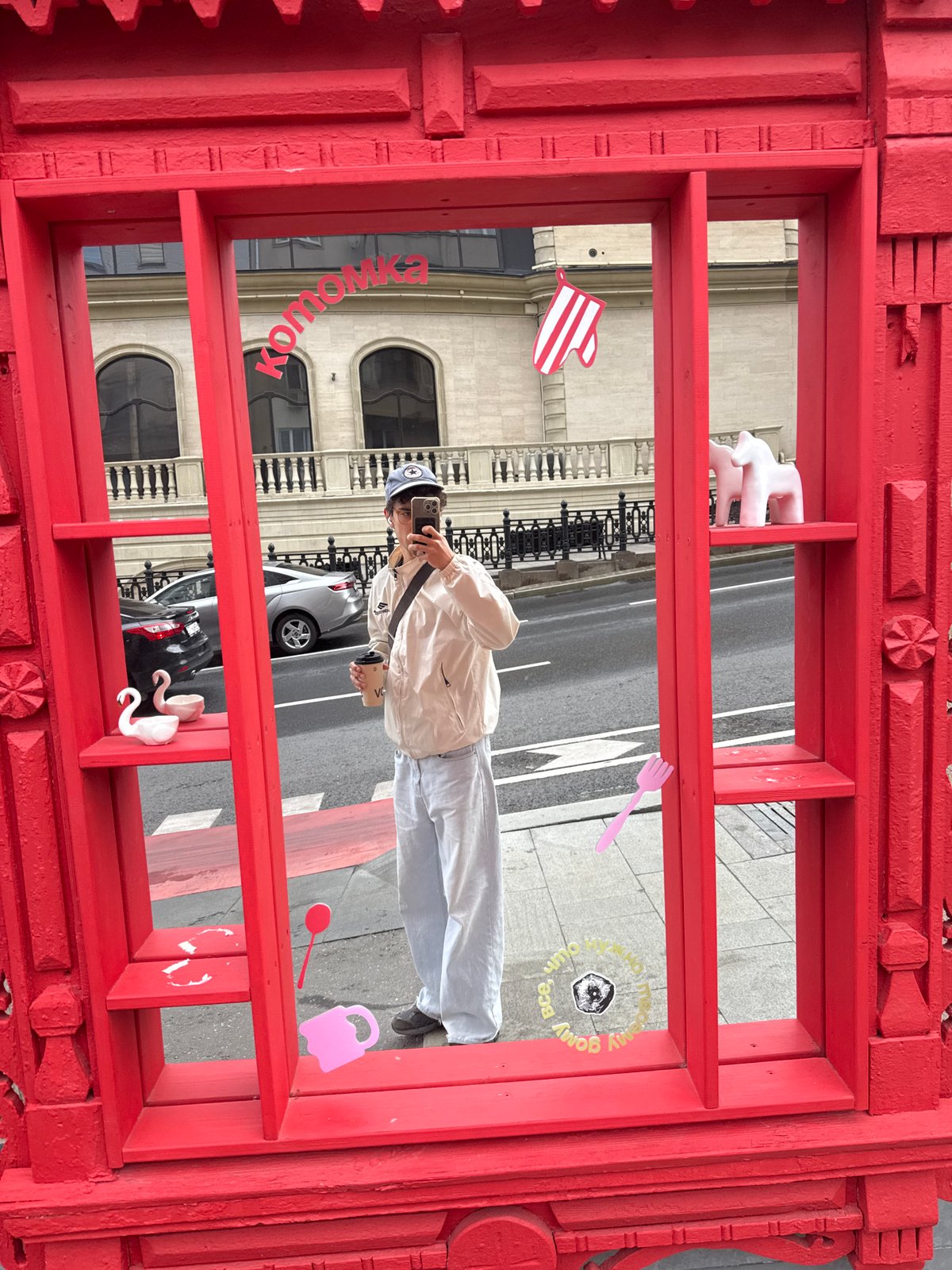 Young person takes selfie behind ornate red frame in Moscow