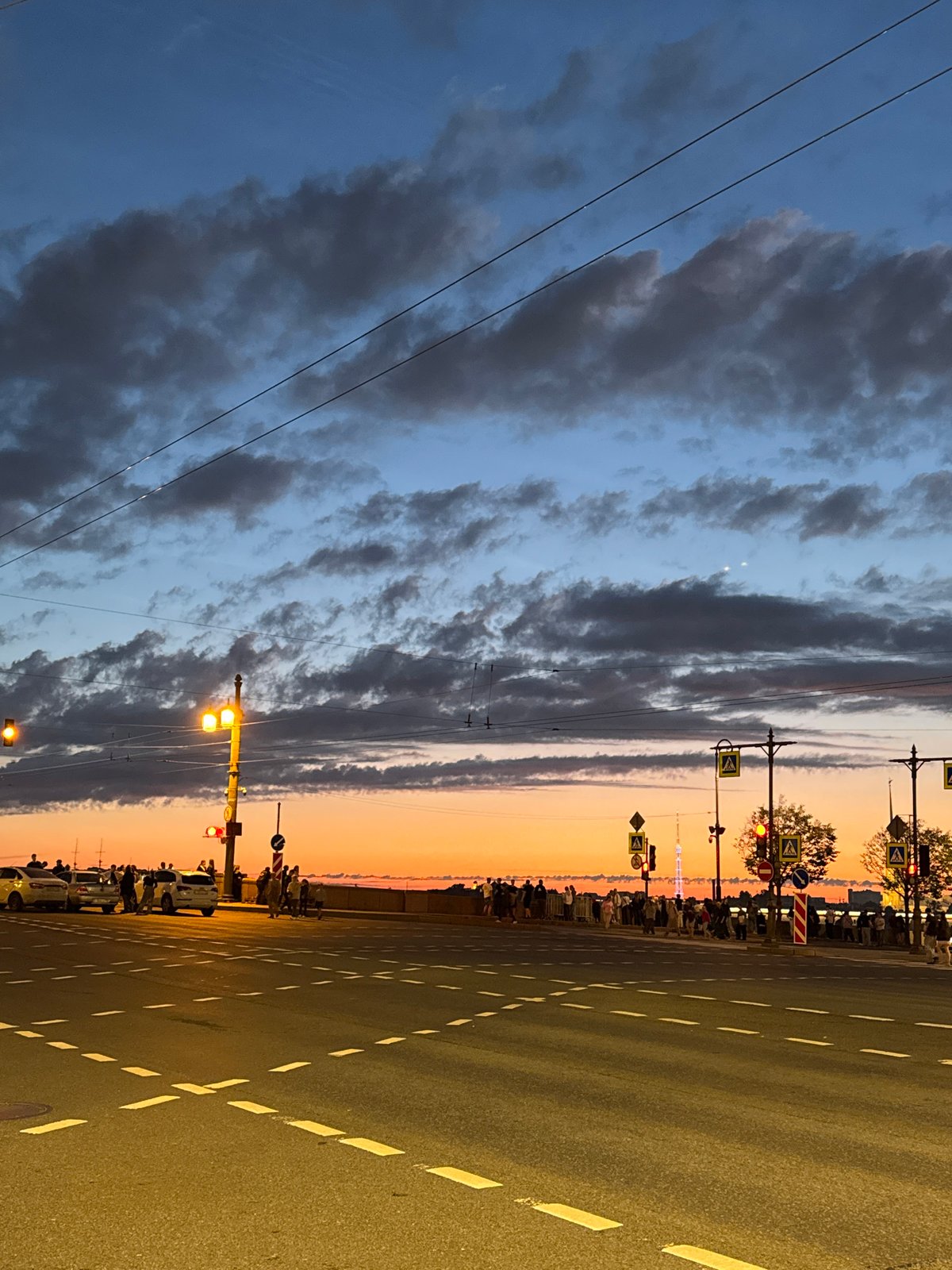 Palace Bridge opens at dusk while crowds gather on the Neva embankment