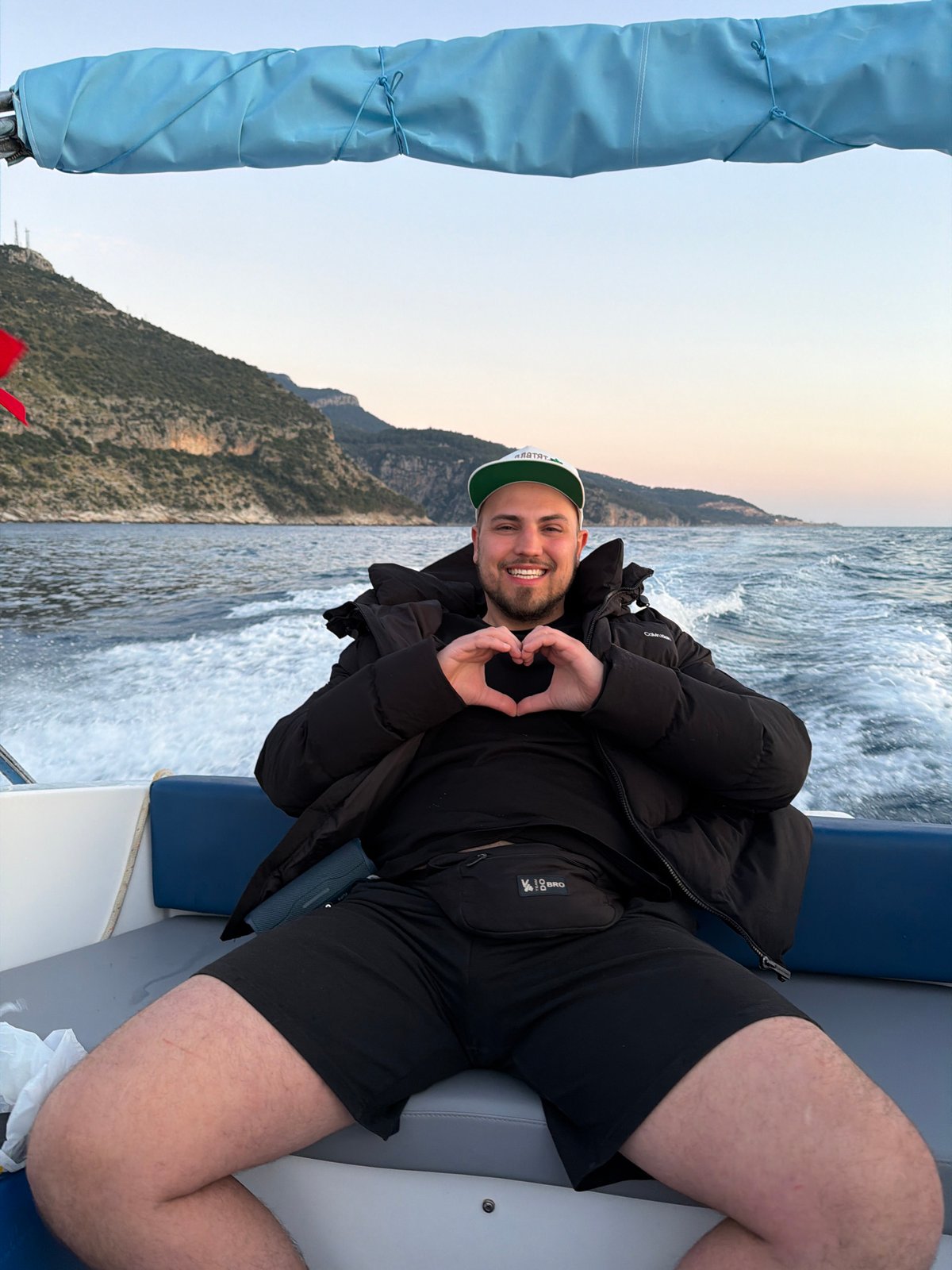 Man Makes Heart Gesture on Boat During Turkish Coast Sunset