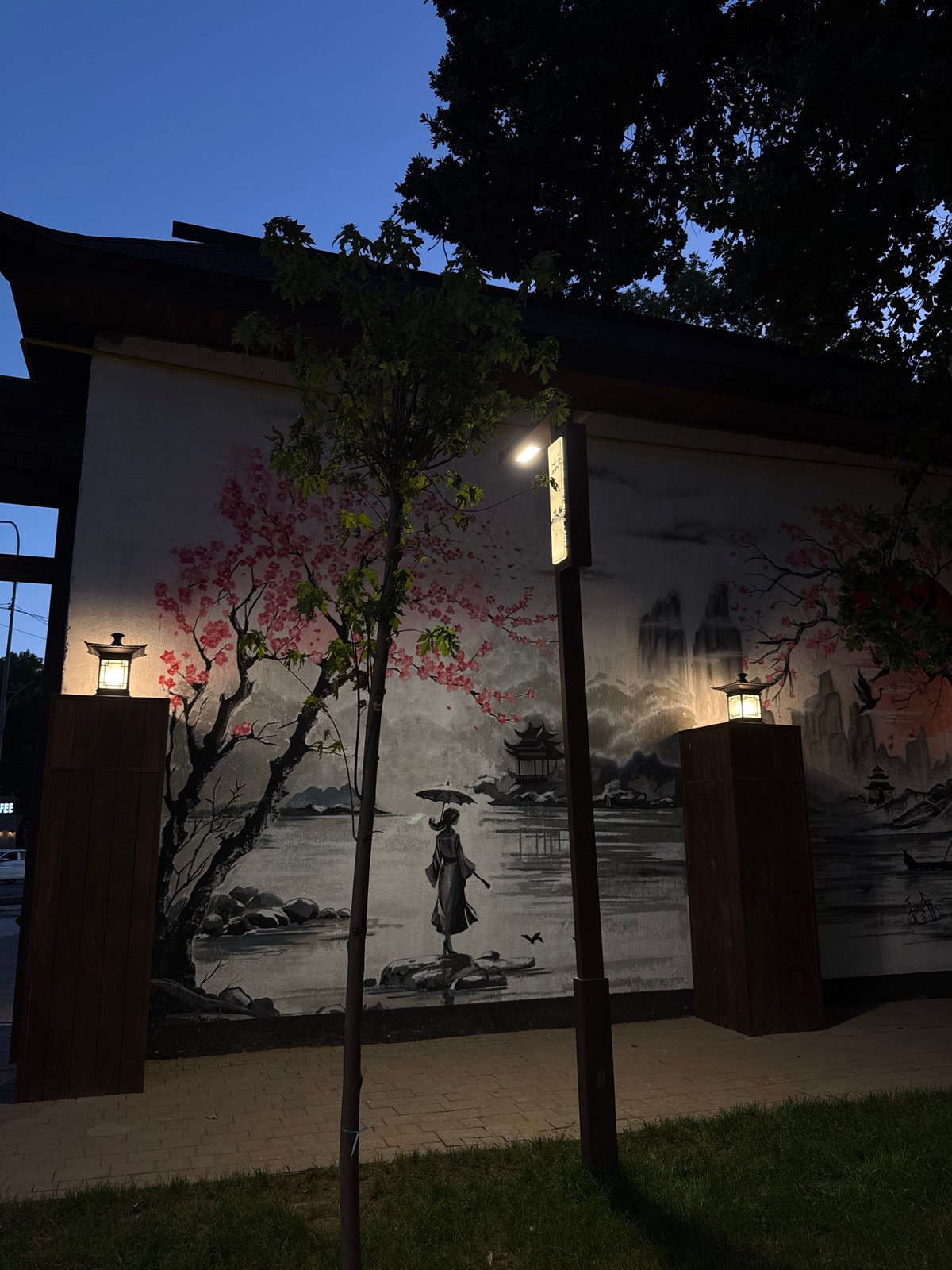 East Asian-style mural on a Shymkent building wall at dusk