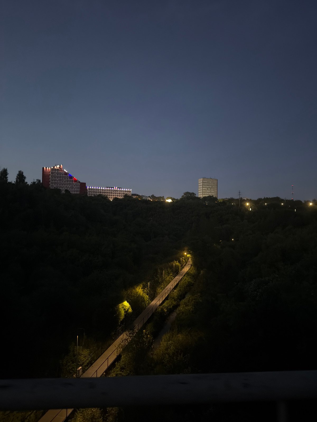 Evening walk along a tree-lined pedestrian bridge in Perm