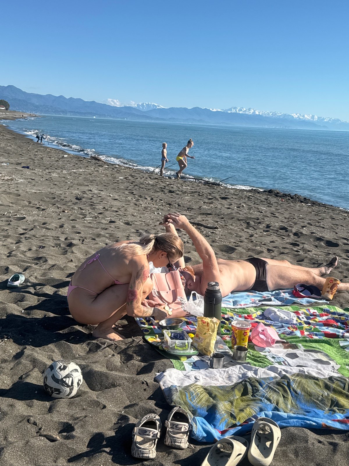 Beachgoers enjoy sunny afternoon at black sand beach