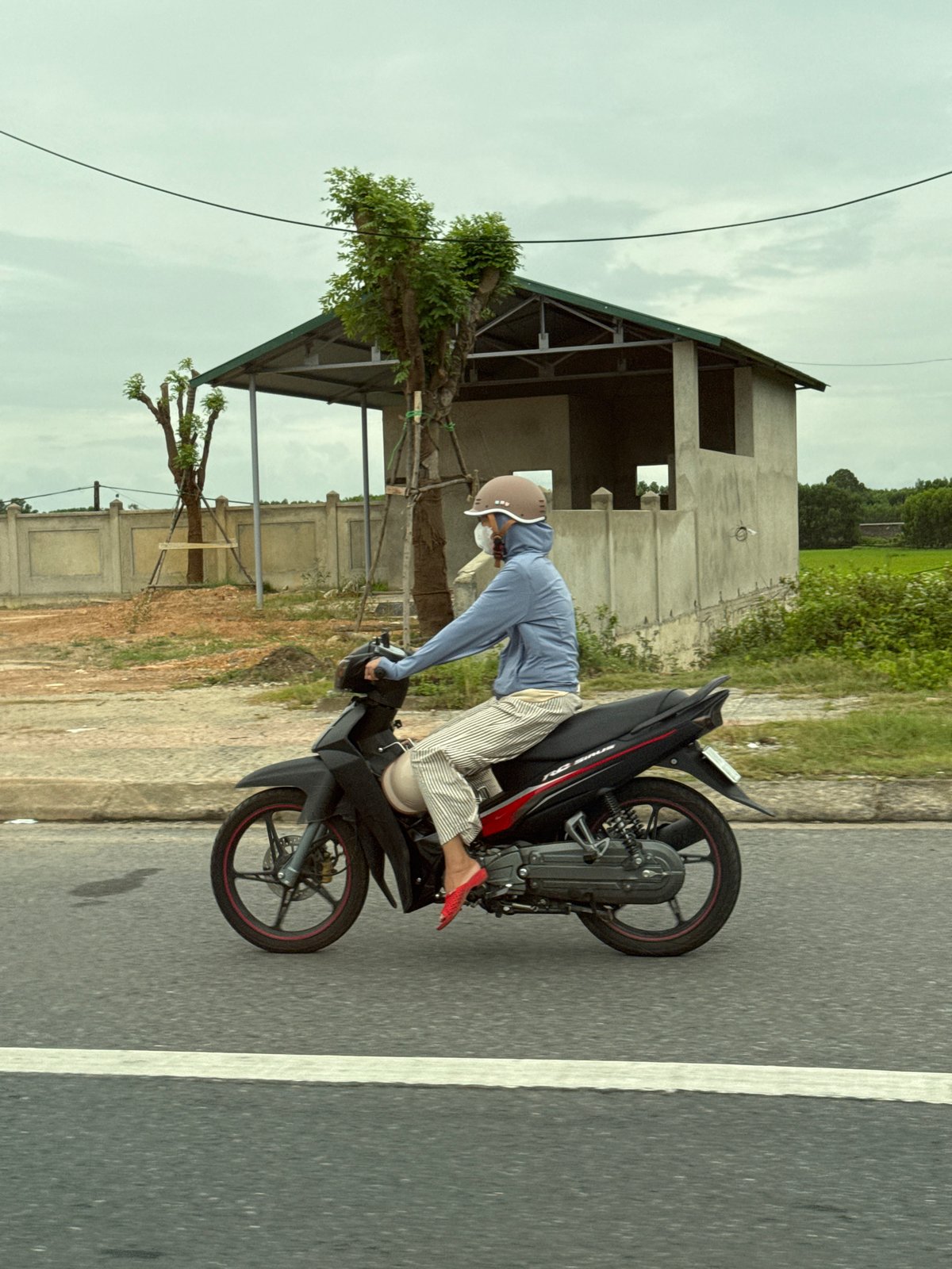 Motorcycle rider cruising through Ái Tử Commune, Vietnam