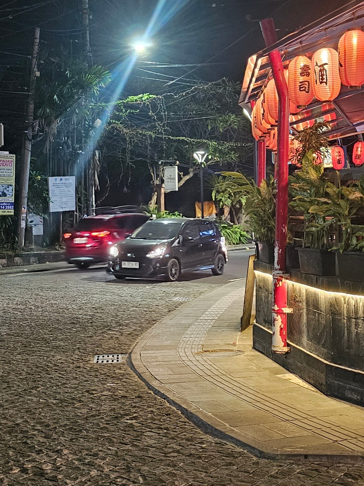 Nighttime street life documented in lantern-decorated Denpasar district