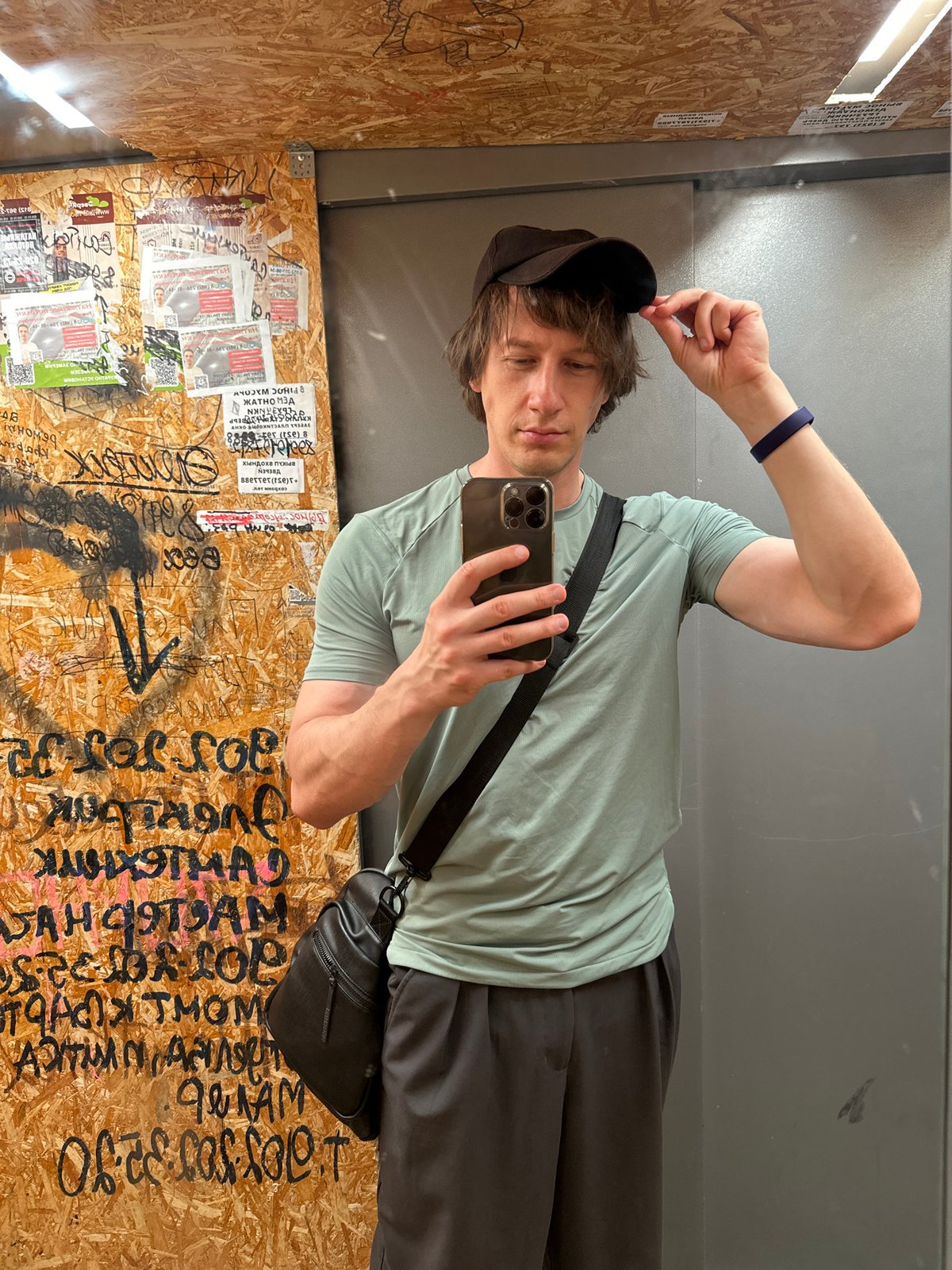 Casual selfie in a wood-paneled elevator or small room