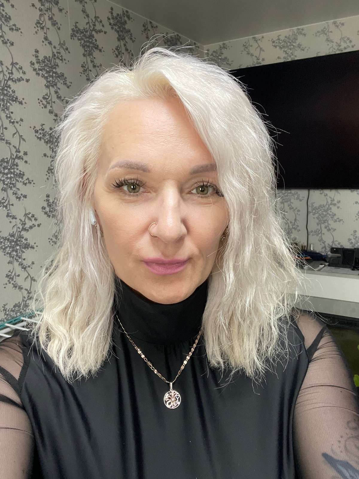 Selfie in black mesh-sleeve top with gold chain accessory