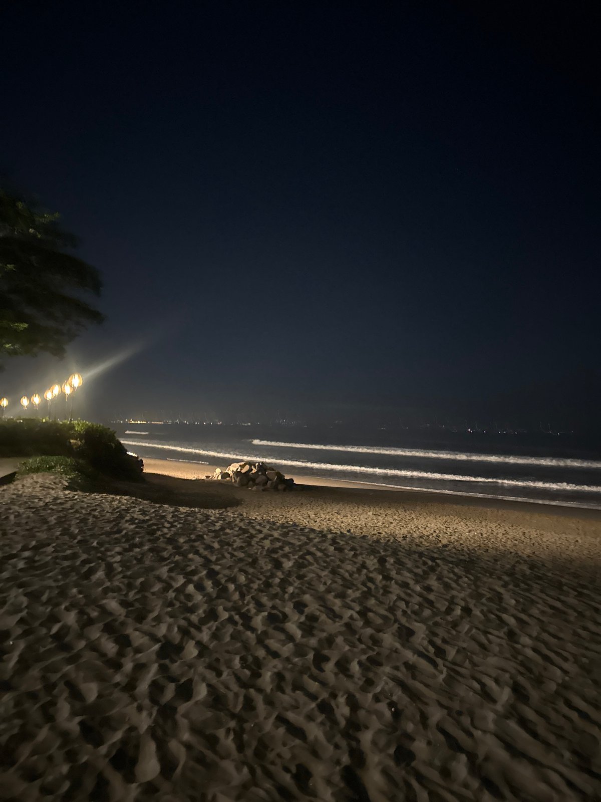 North Kuta beachfront lit up at night with string lights and surf