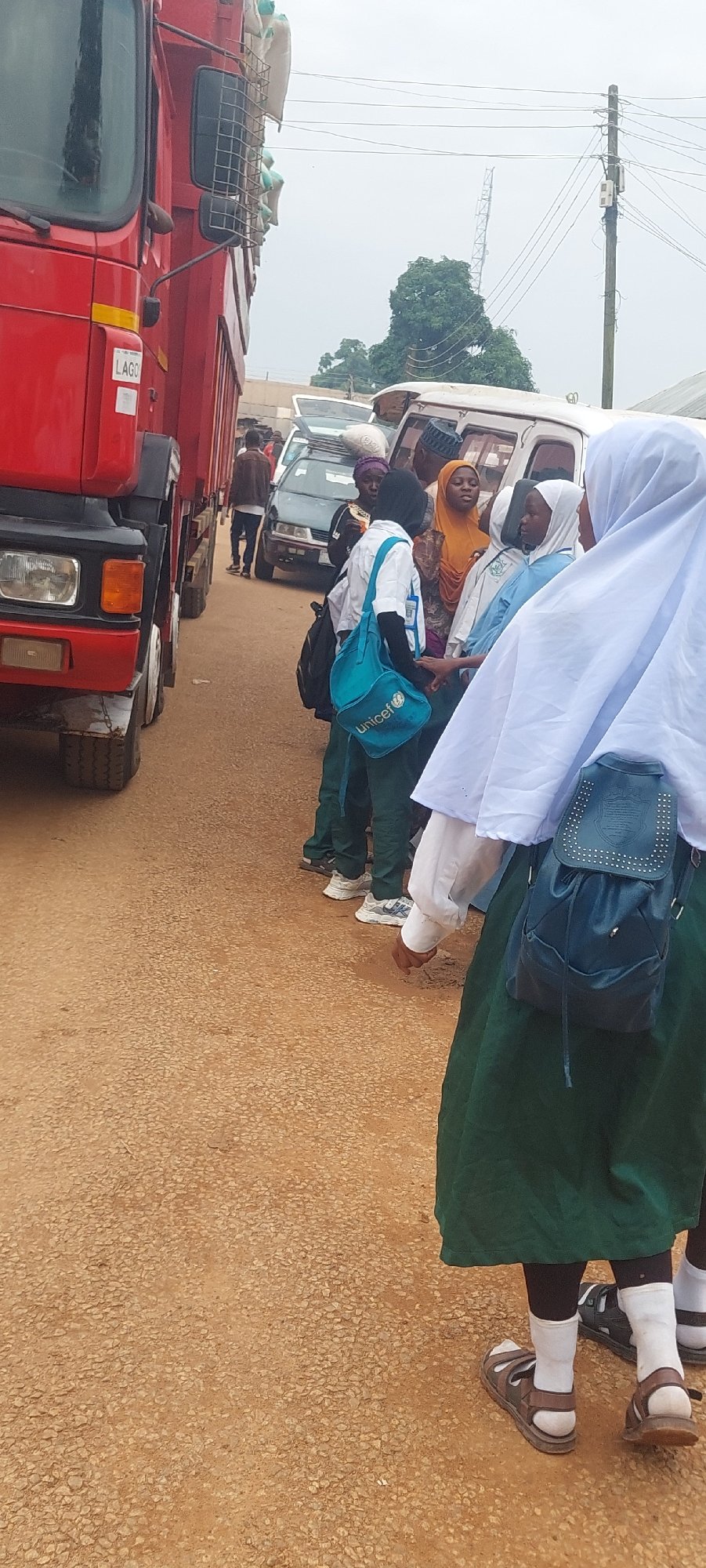 Market day activity around grain truck and street vendors