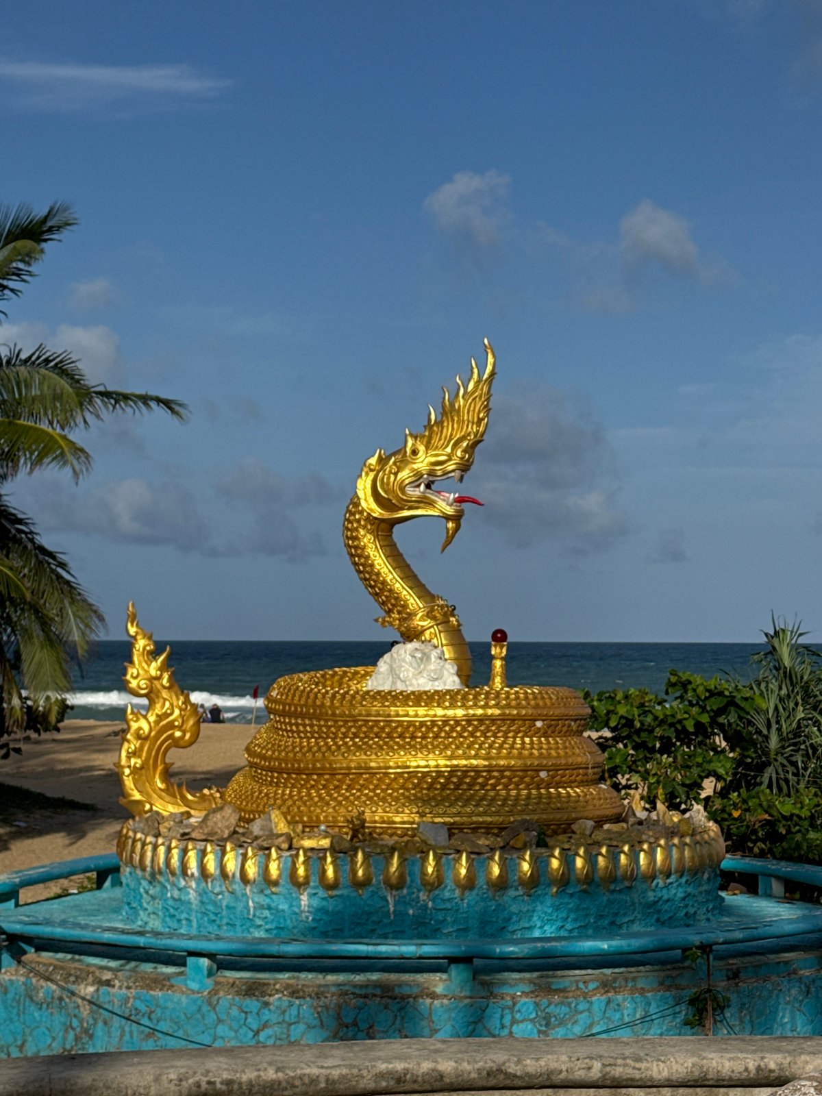 Karon beach morning: waves, a serpent statue, and a 7-Eleven run