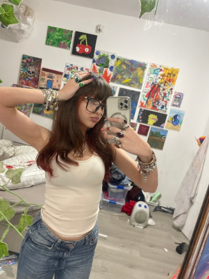 Young woman takes mirror selfies in decorated bedroom in Ra'anana
