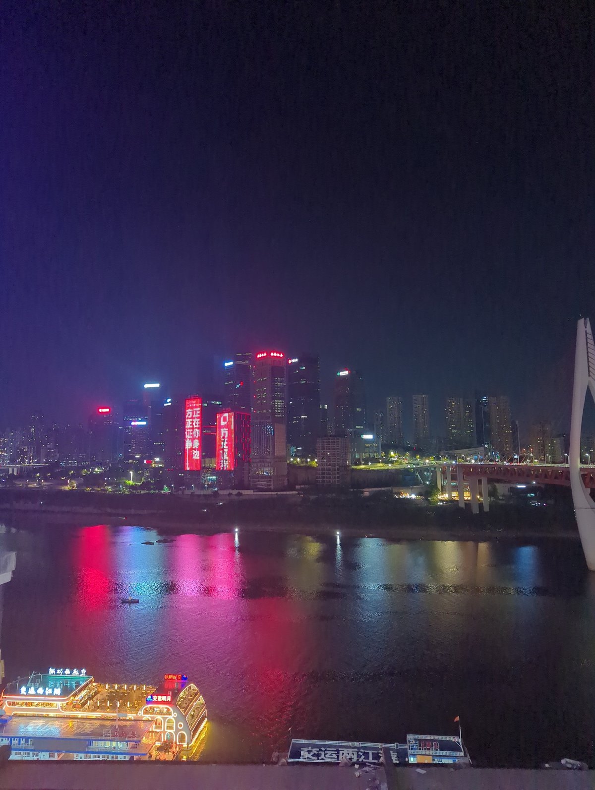 Chongqing's Yuzhong waterfront glows at night with docked river boat