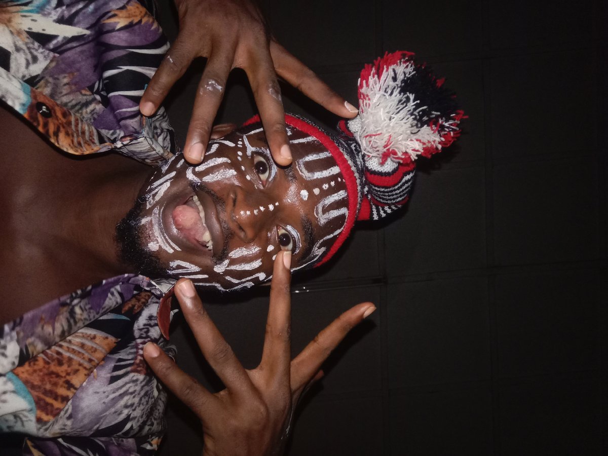 Individual photographed in traditional ceremonial face paint and attire