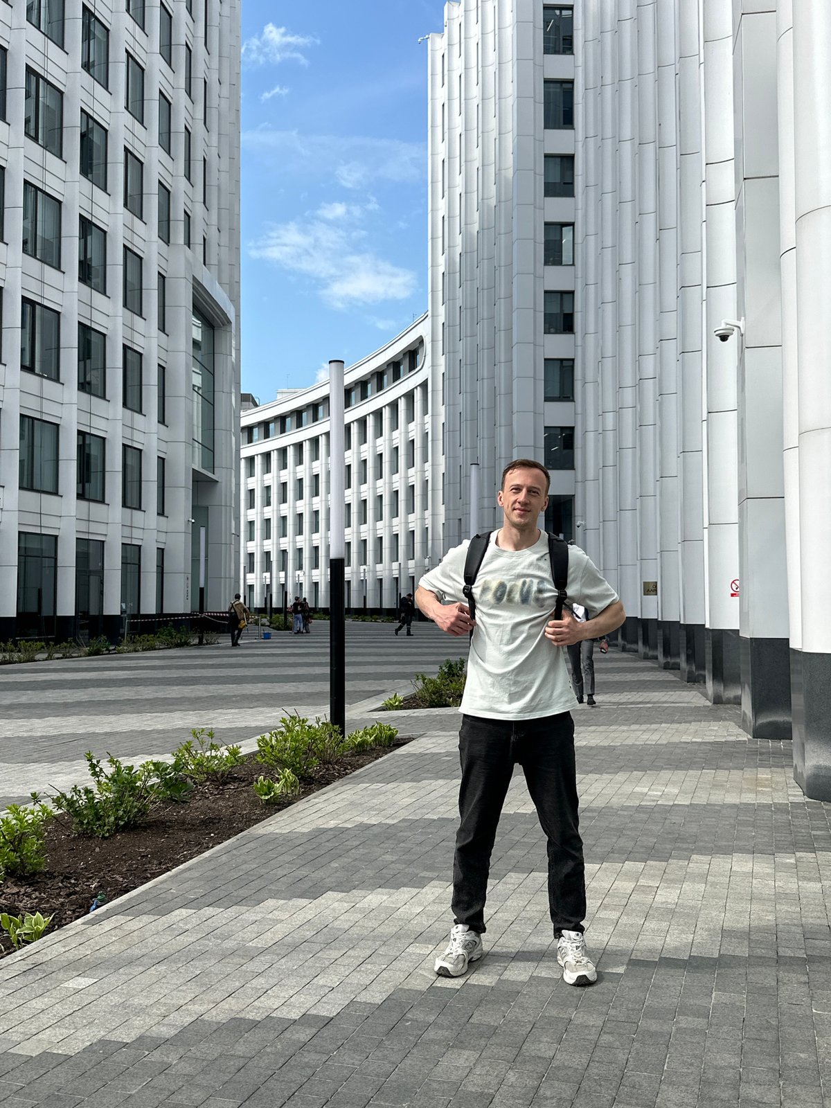 Man with backpack crosses Moscow courtyard near barricades