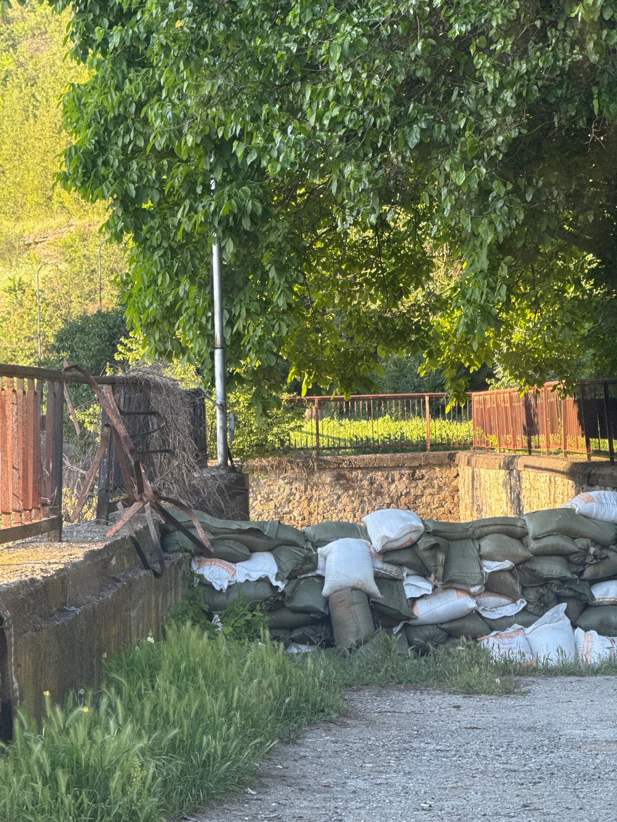 Urban riverfront gathering documented amid construction and flood preparations