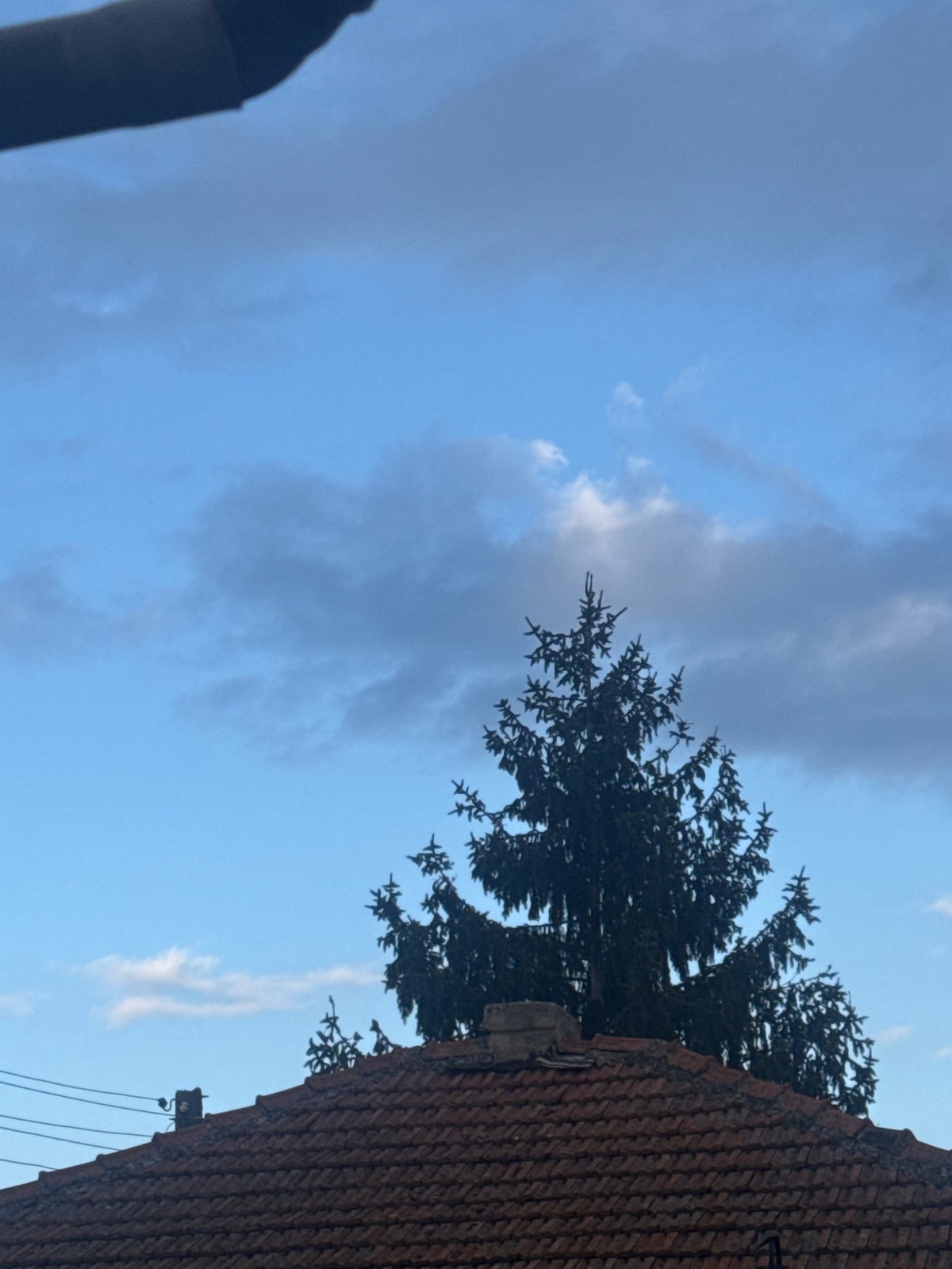 Residential scene with red-tiled building documented under cloudy sky