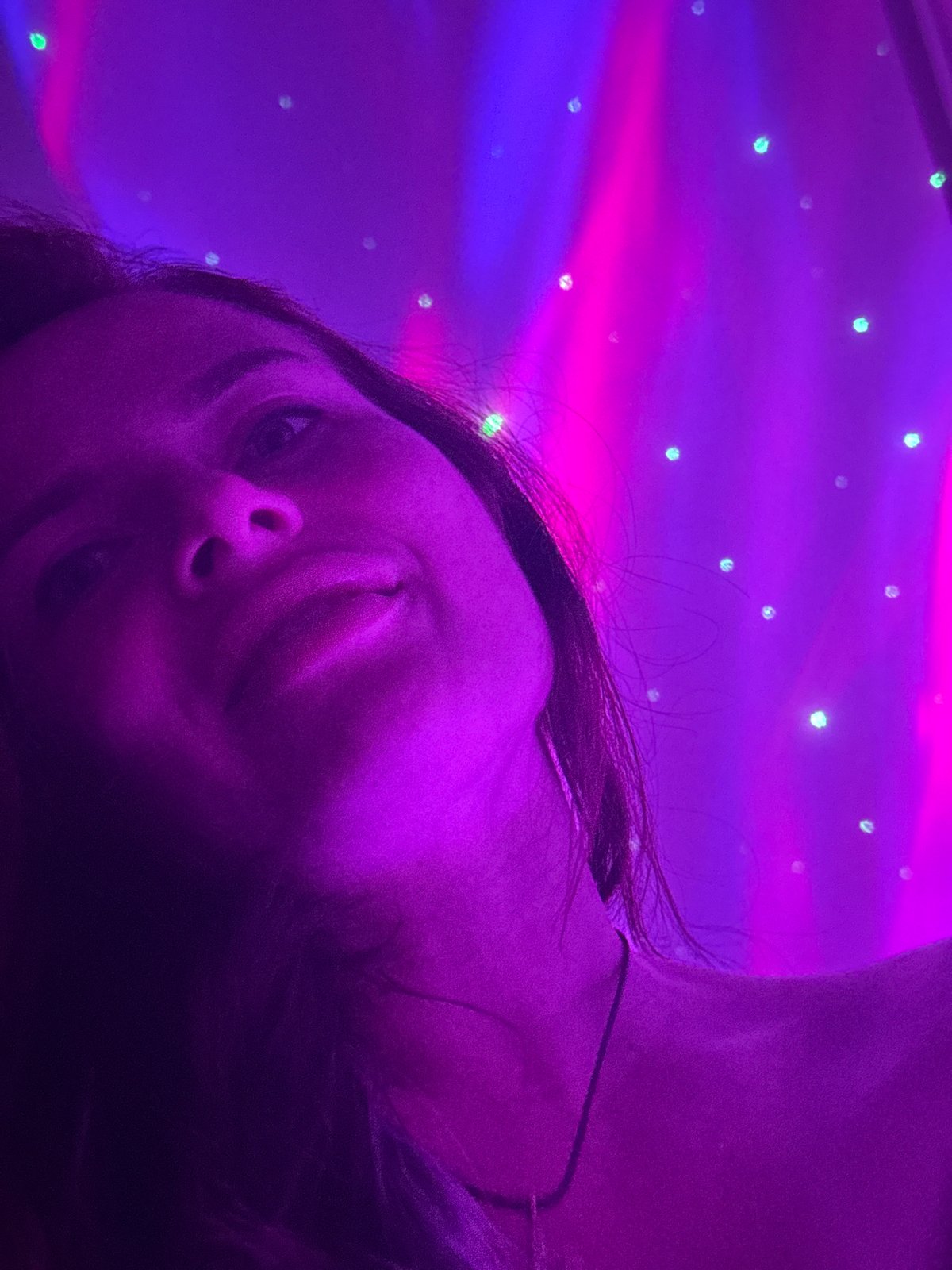 Portrait session under purple and pink atmospheric lighting indoors