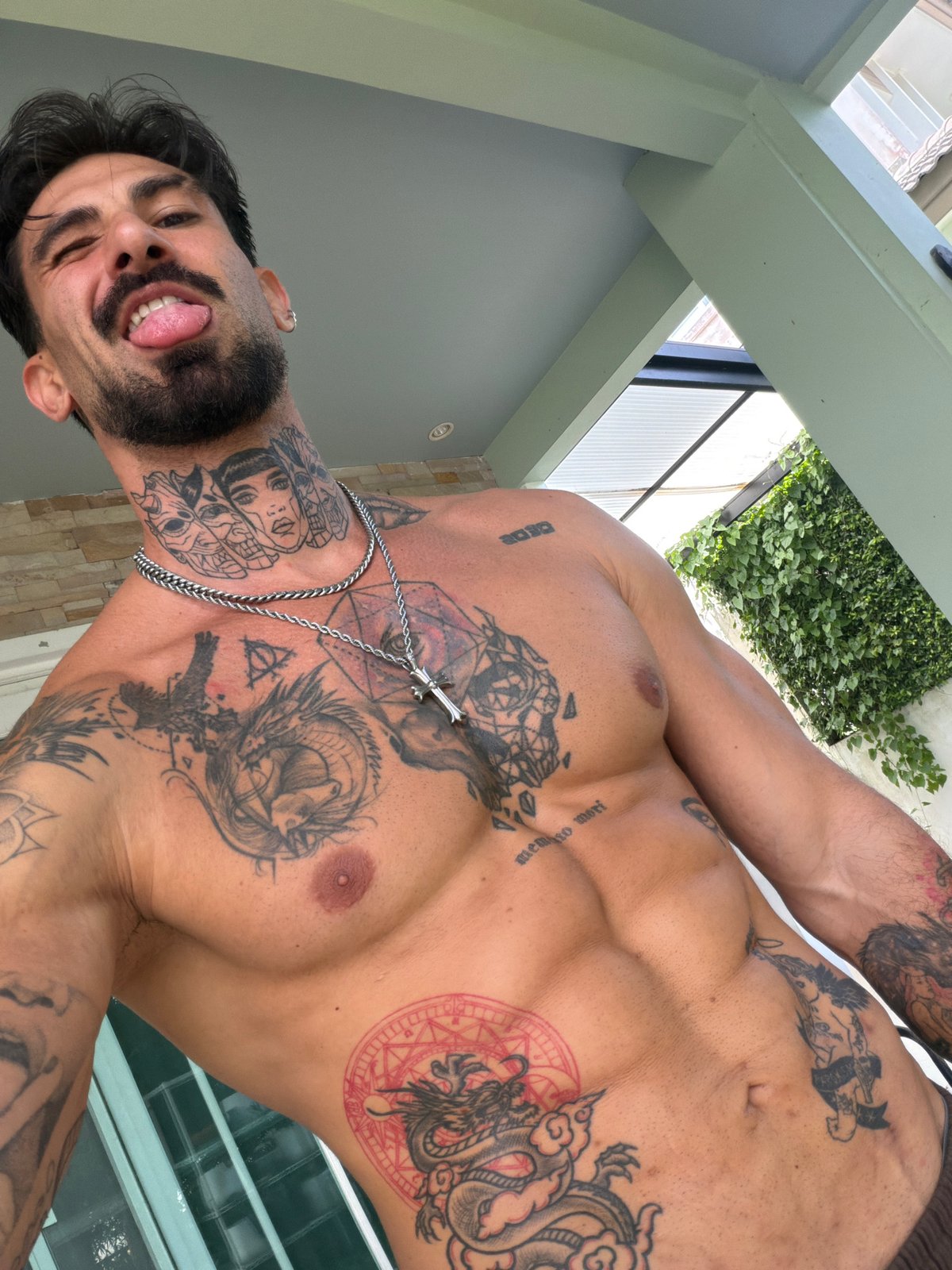 Tattooed man takes playful selfie in Chalong, Thailand