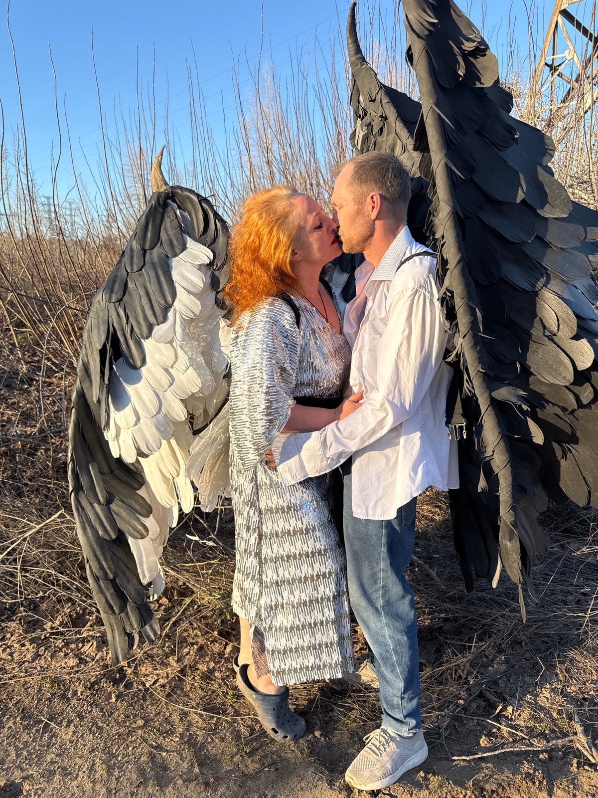 Couple in theatrical wings embrace in Chaikovsky, Russia